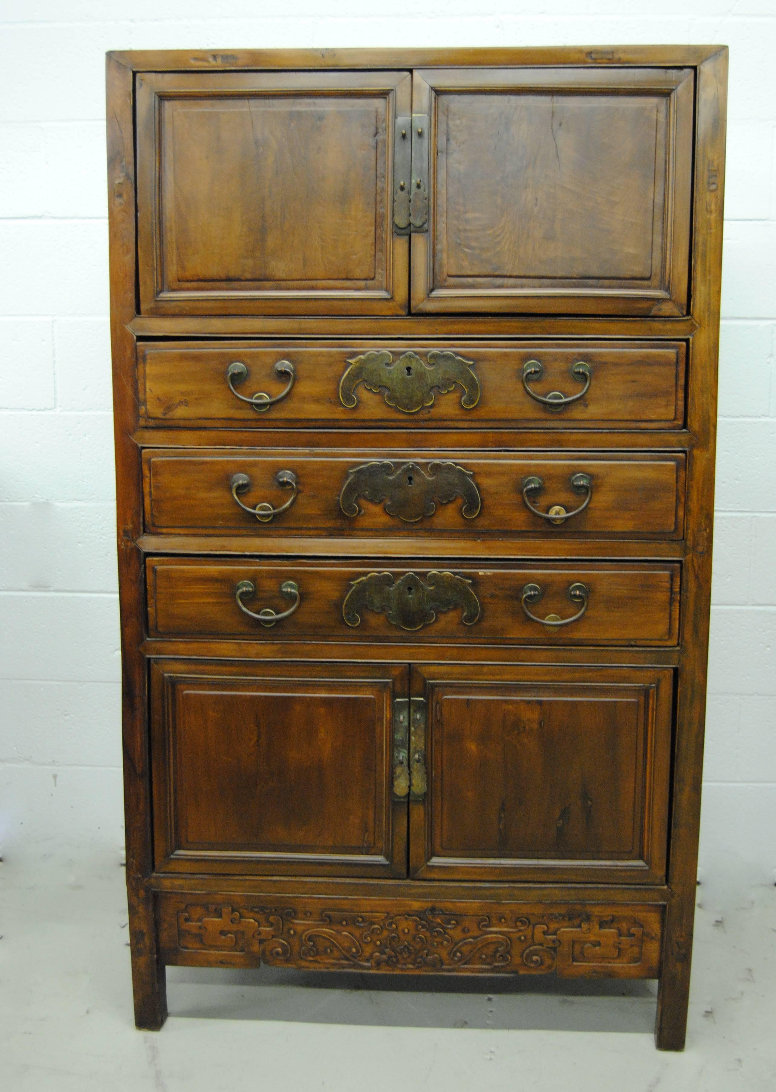 19th century double bay, three-drawer tall cabinet with original finish. Very nicely hand-carved lower apron. The outstanding hardware is original to the piece. The Nan Mu has a beautiful grain, rich color.