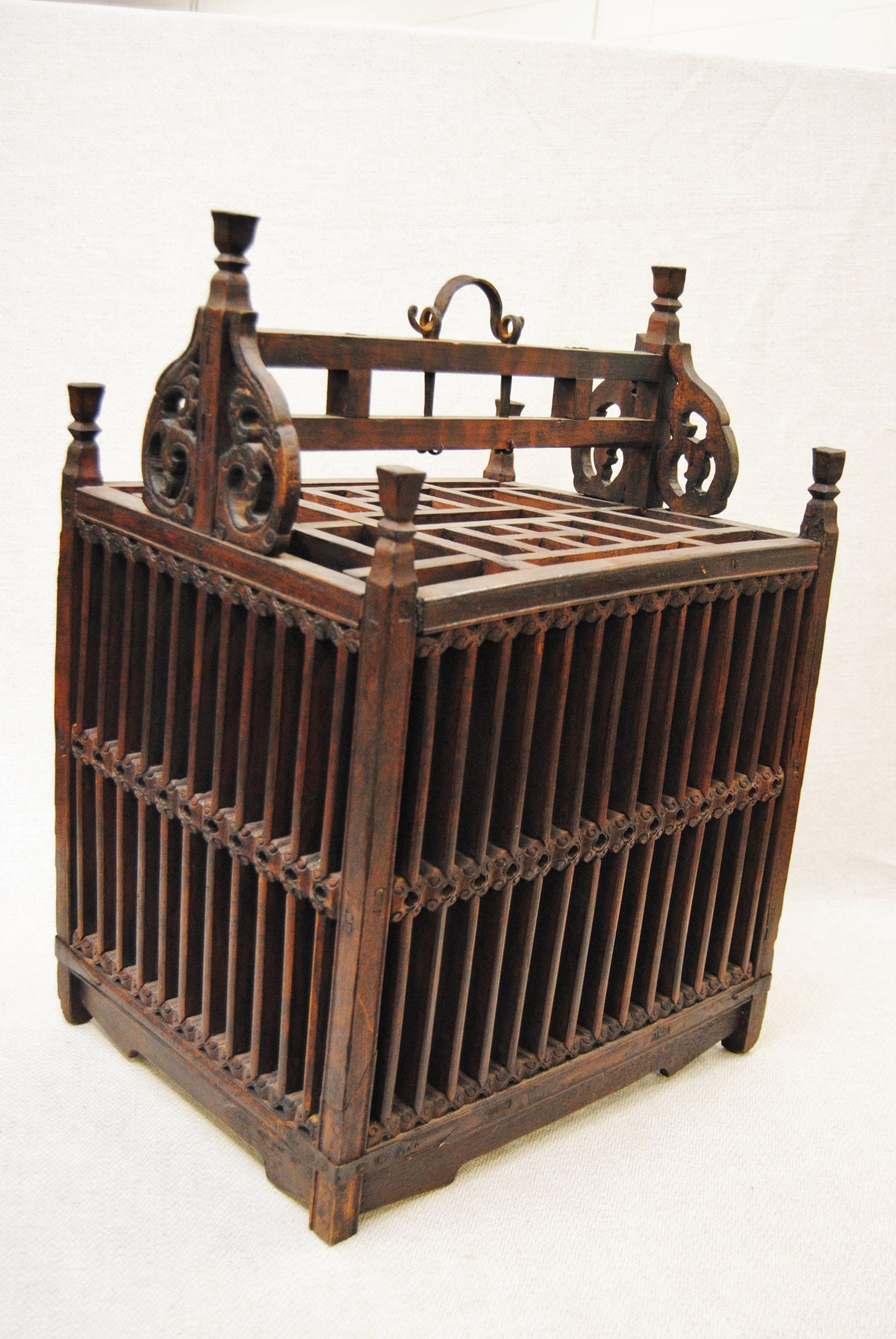 Hand-carved Chinese bird or animal cage that was made to be given as a wedding gift, circa 1850. This is a large, heavy cage with detailed carving. There is a hand-forged iron handle and a small opening at the top. A very rare Chinese piece of