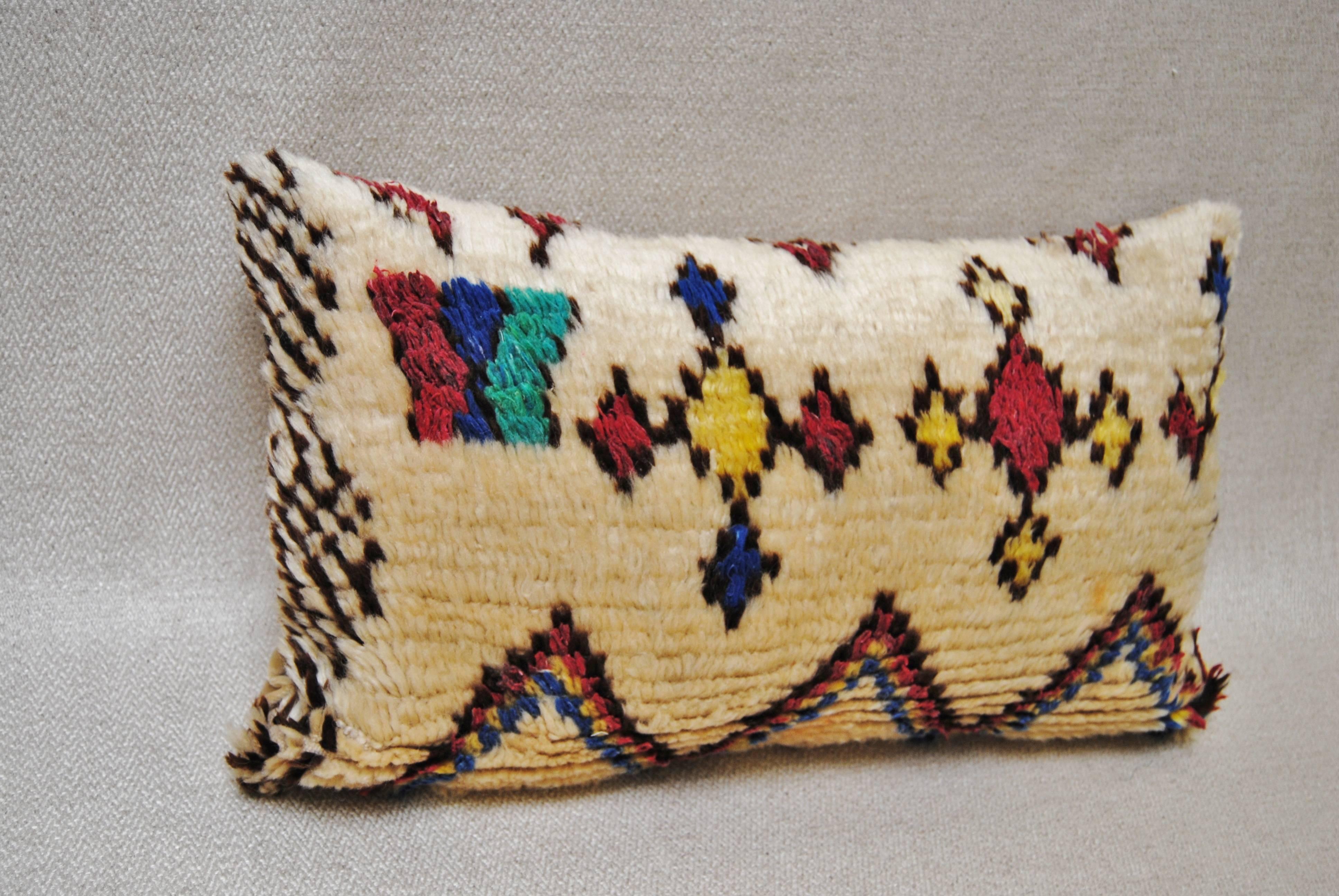 Custom pillow cut from a vintage hand-loomed wool Moroccan Azilal rug from the Atlas Mountains. Wool is soft and lustrous with all natural dyes. Whimsical tribal designs in vibrant colors. Pillow is backed in cream mohair, filled with an insert of