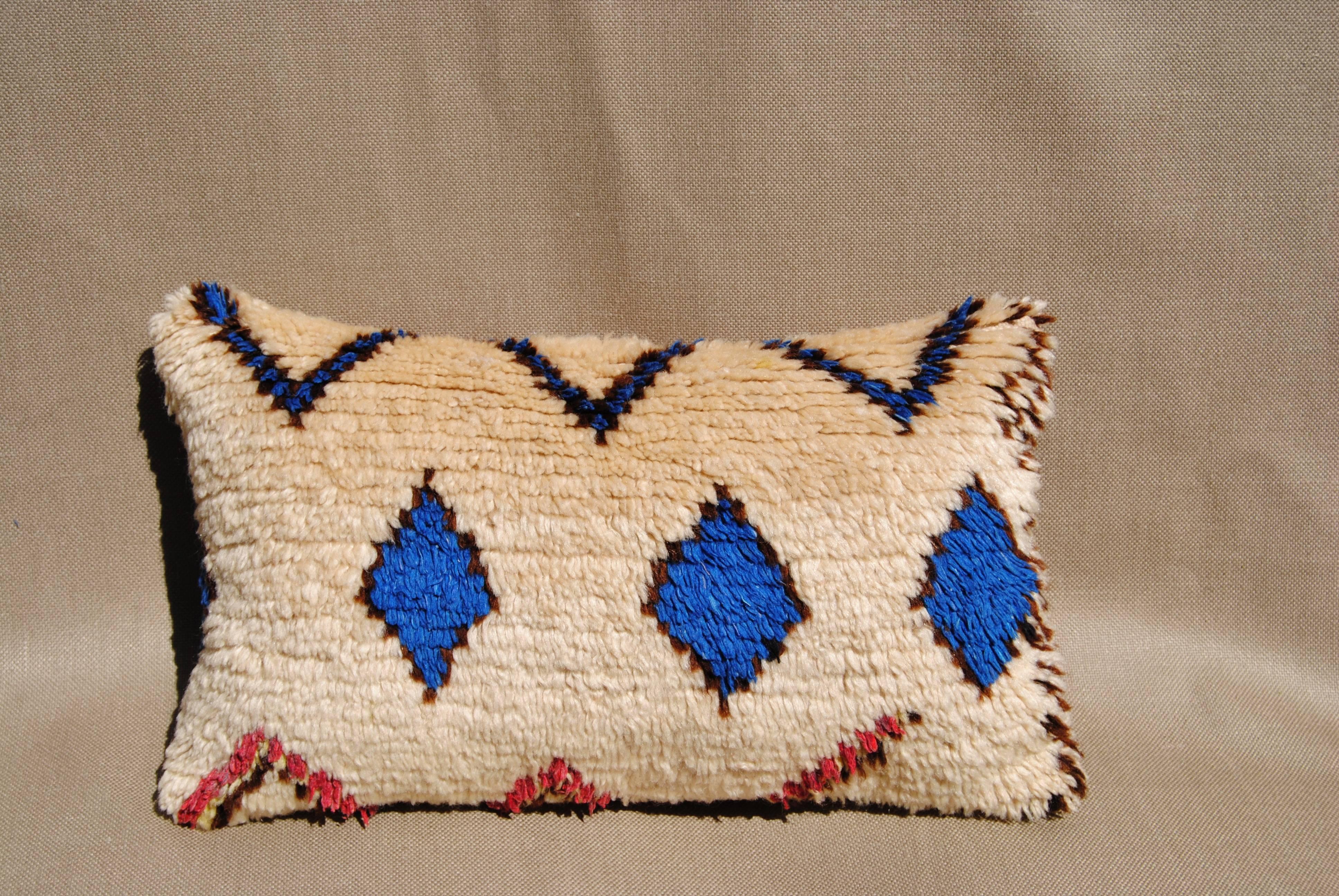 Custom pillow cut from a vintage hand-loomed wool Moroccan Azilal rug from the Atlas Mountains. The wool is soft and lustrous with natural dyes. The pillow is backed in ivory mohair, filled with an insert of 50/50 down and feathers and hand-sewn