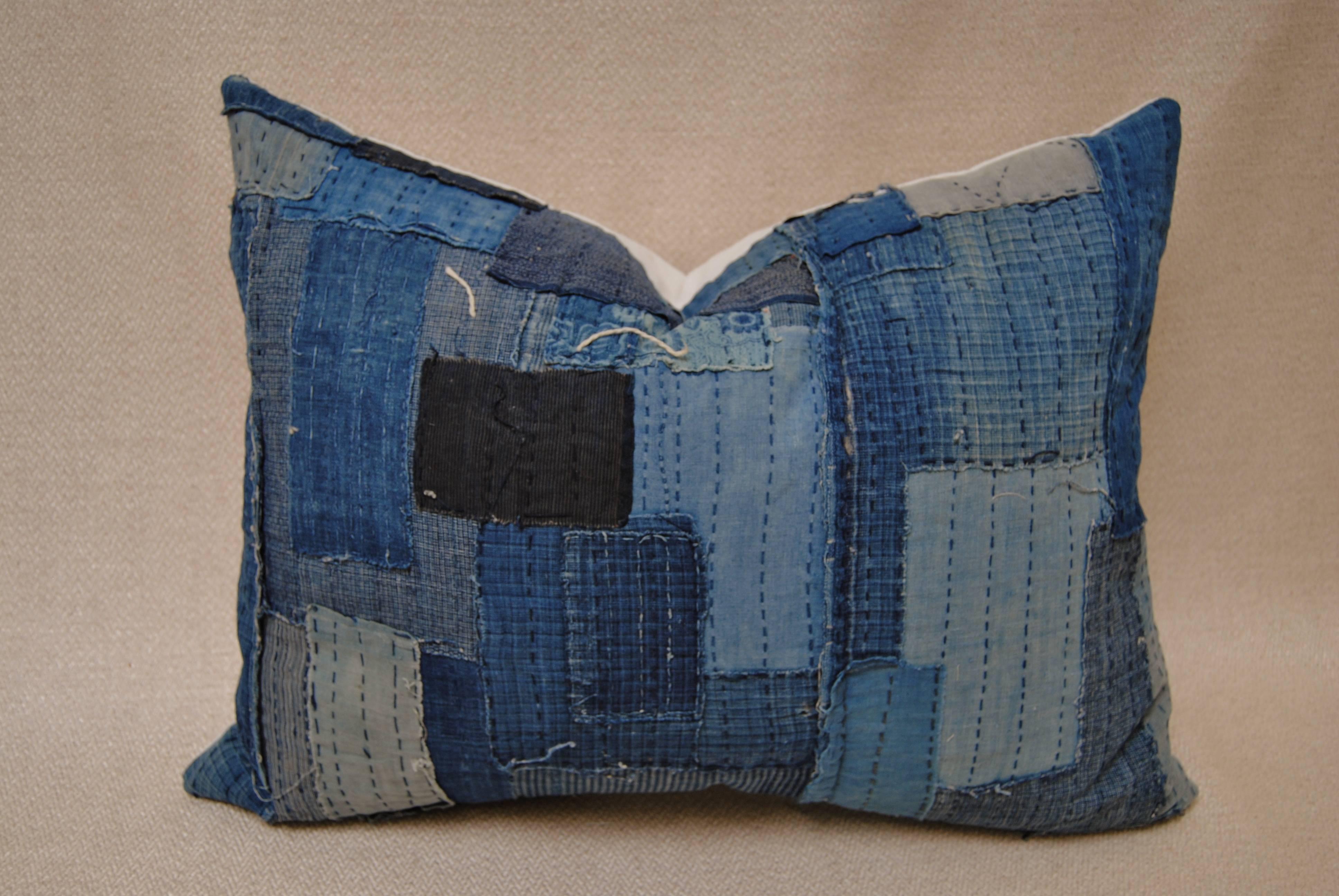 Custom pillow cut from an antique Japanese Boro futon cover.  Made from patches of cotton indigo with sashiko stitching.  Once considered a utilitarian object, the boro textile is now seen as a piece of art.  Pillow is backed in off white hand