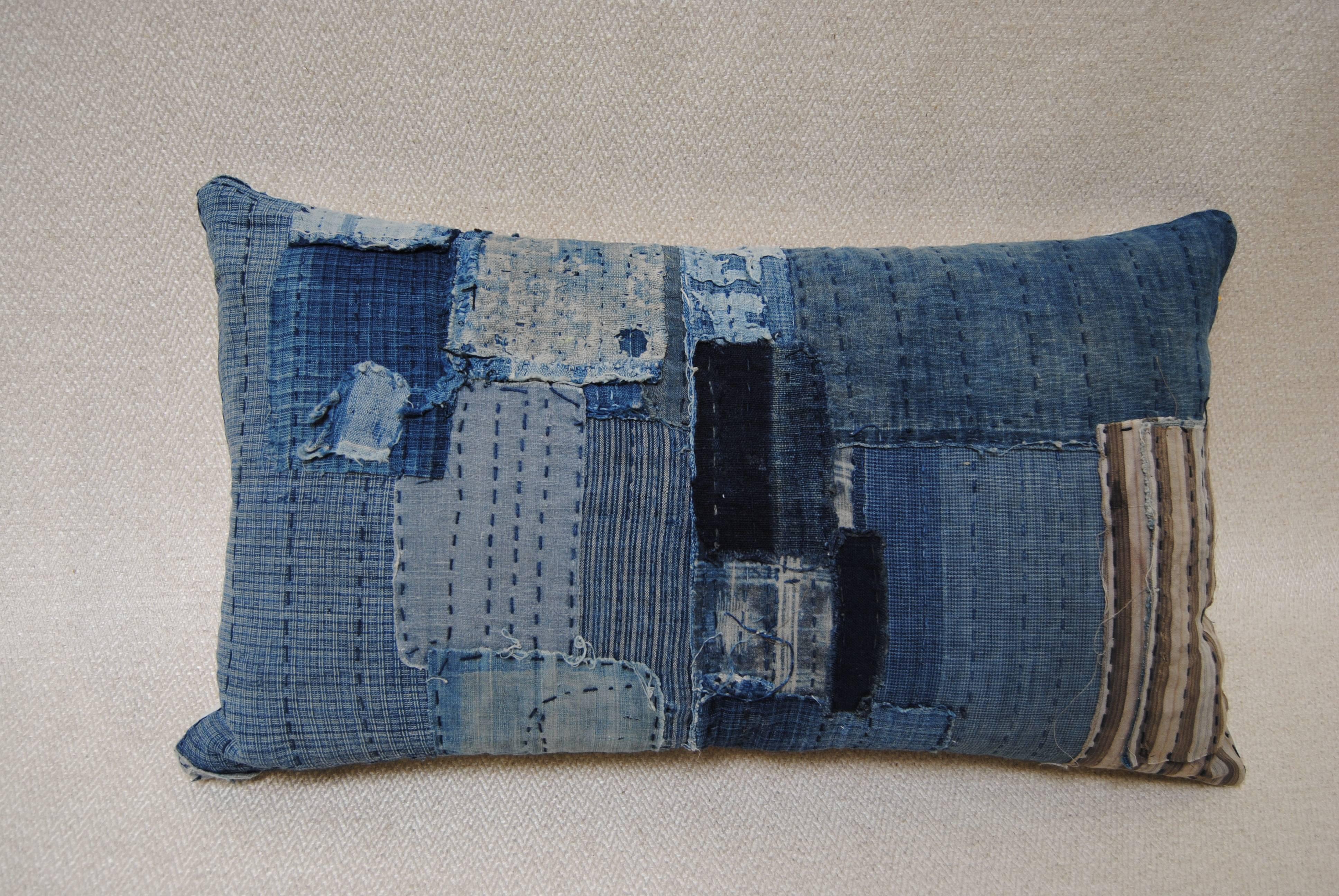 Custom pillow cut from an antique Japanese Boro futon cover.  The boro is made from scraps of hand loomed indigo that are patched and stitched together with sashiko stitching by the poor Japanese farmers and fisherman.  Once considered a utilitarian