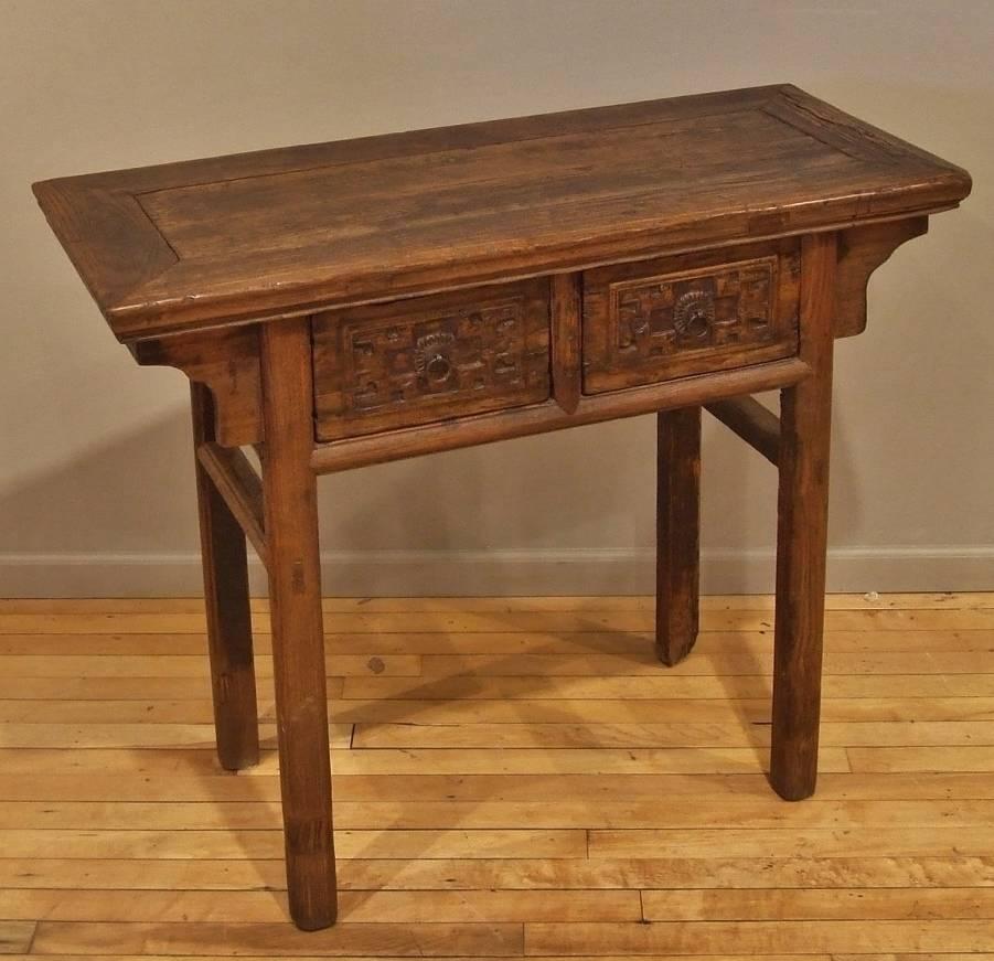 Antique Chinese Elmwood side table, mid-19th century, with hand-carved detail on the two drawers and simple spandrels.