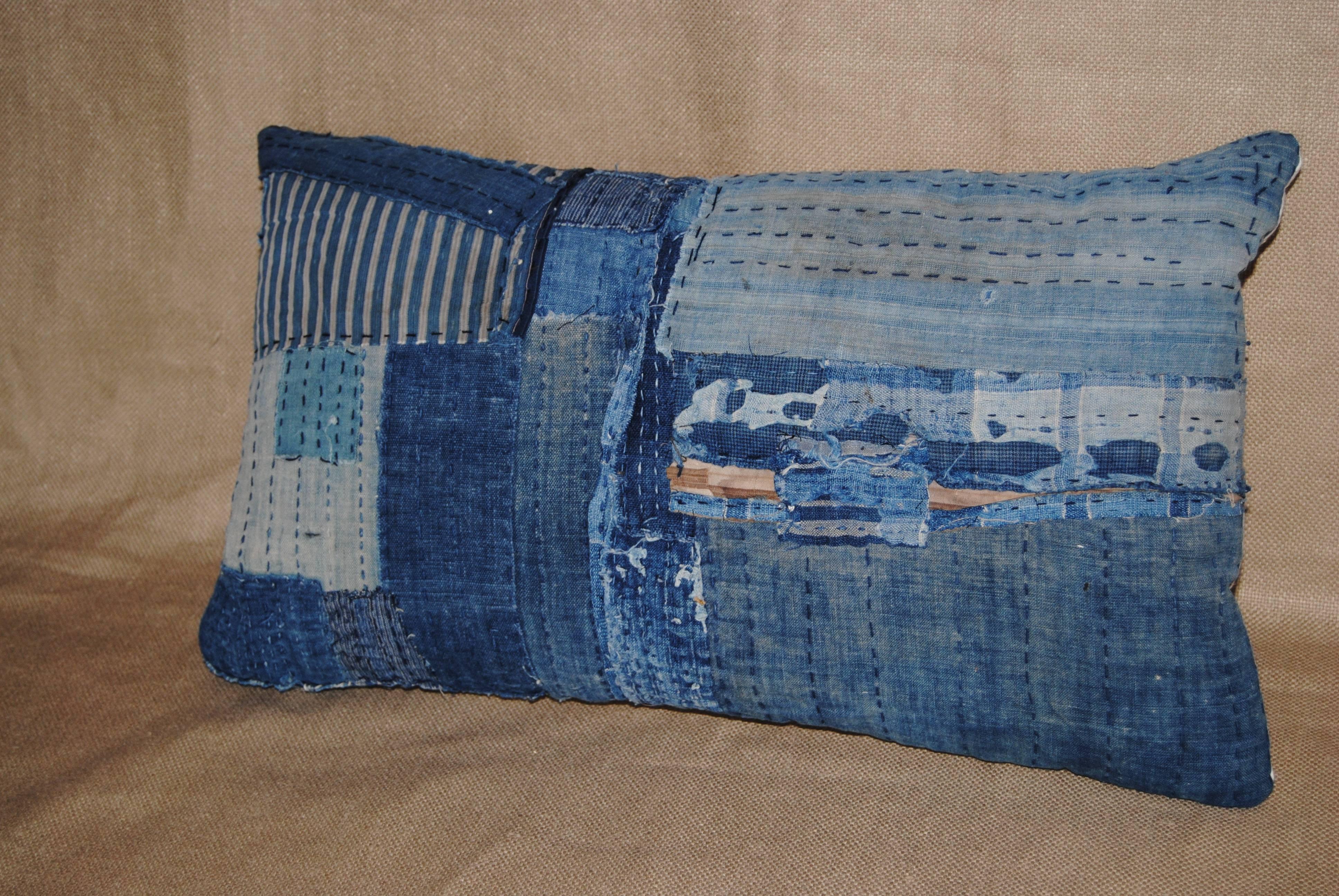 Custom pillow cut from an antique Japanese indigo boro futon cover. The farmers and fisherman were not allowed to wear silk. Every scrap of hand loomed cotton indigo was saved for clothing and futon covers, patched together with sashiko stitching.