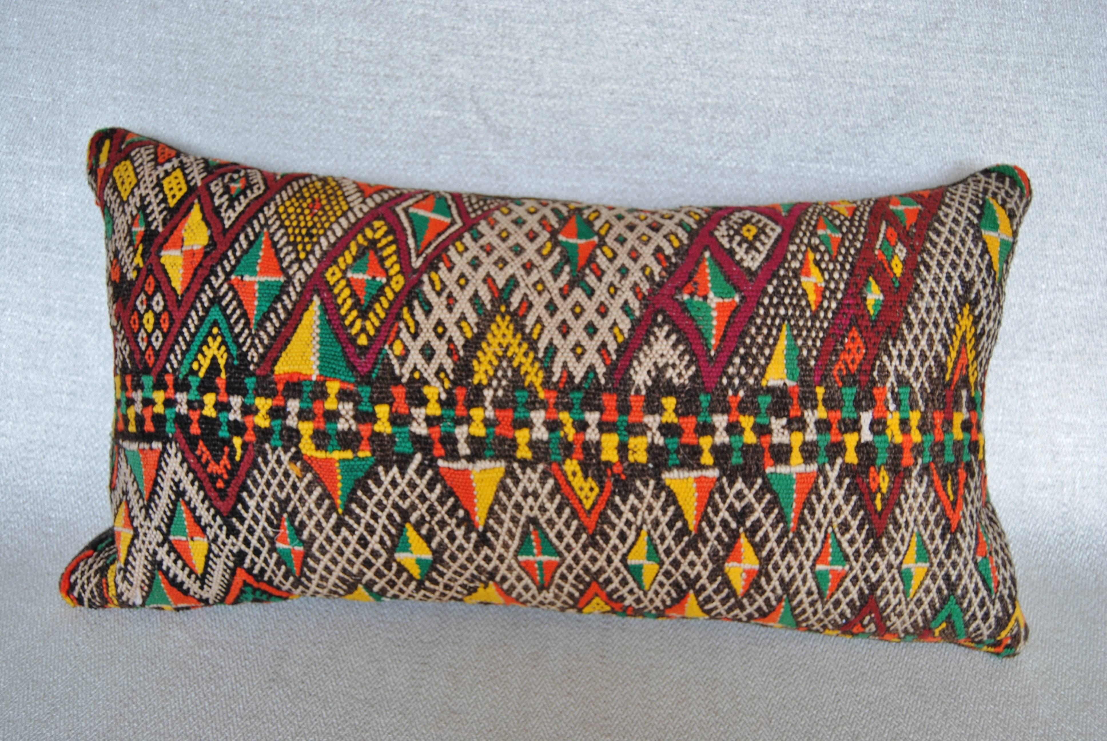 Custom pillow cut from a hand loomed wool Moroccan rug from the Atlas Mountains.  Very thickly woven wool, the rug was used as a storage bag for clothing and bedding.  Pillow is backed in a dark brown linen, filled with an insert of 50/50 down and