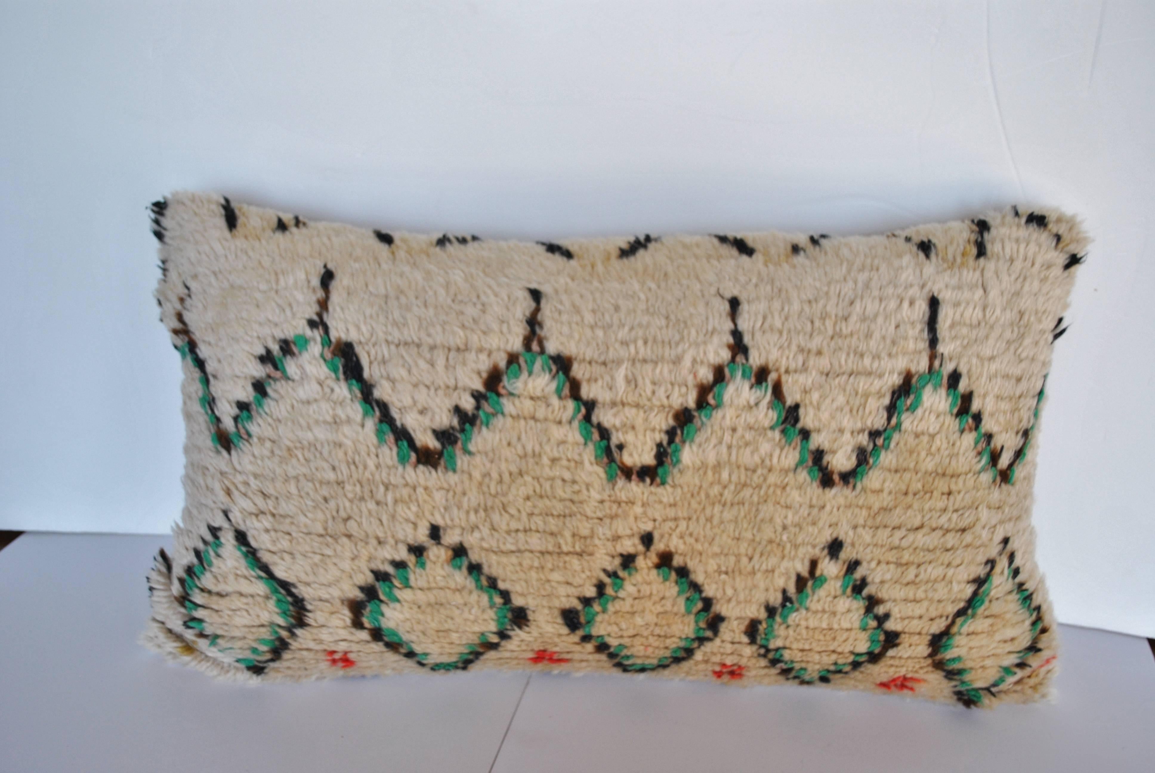 Custom pillow cut from a vintage hand loomed wool Moroccan Azilal rug from the Atlas Mountains. Wool textile is soft and lustrous with tribal designs in natural dyes. Pillow is backed in a soft beige mohair, filled with an insert of 50/50 down and
