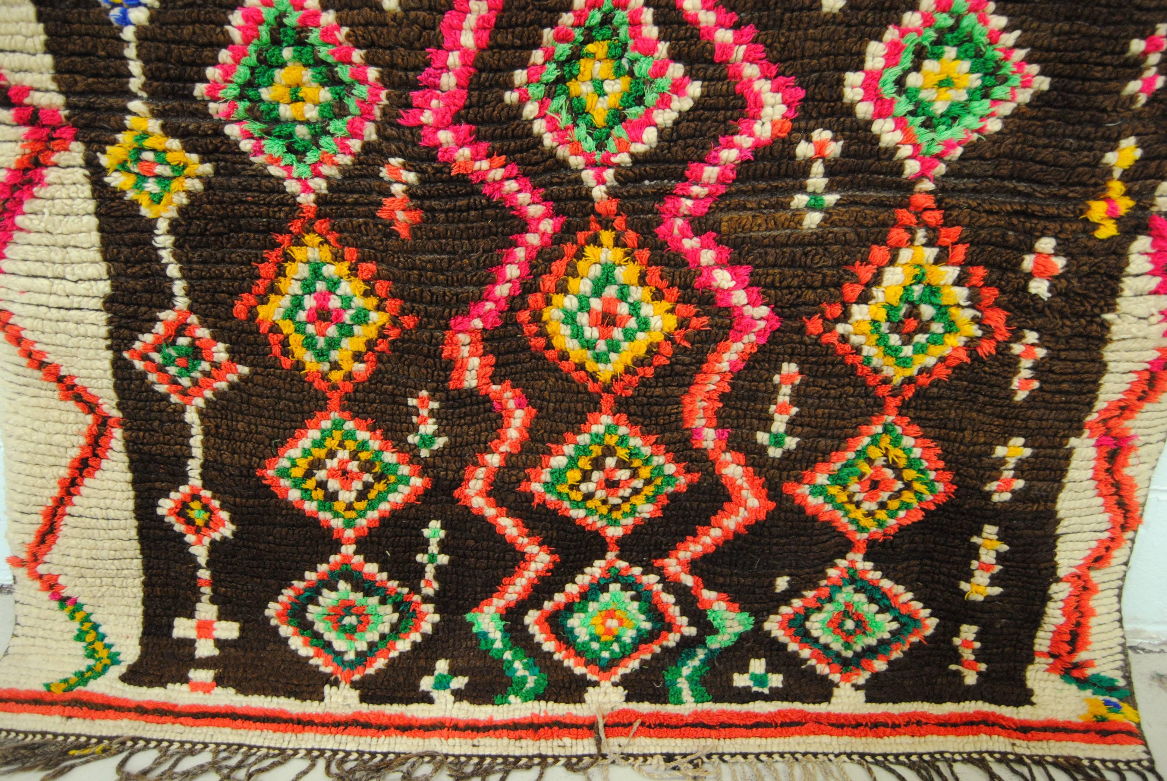 Moroccan hand-loomed wool Ourika Berber rug from the Atlas Mountains. Textile has a thick wool pile with colorful tribal designs. Rug has been recently professionally cleaned and is ready for display on the wall or floor. Measures: 4'10