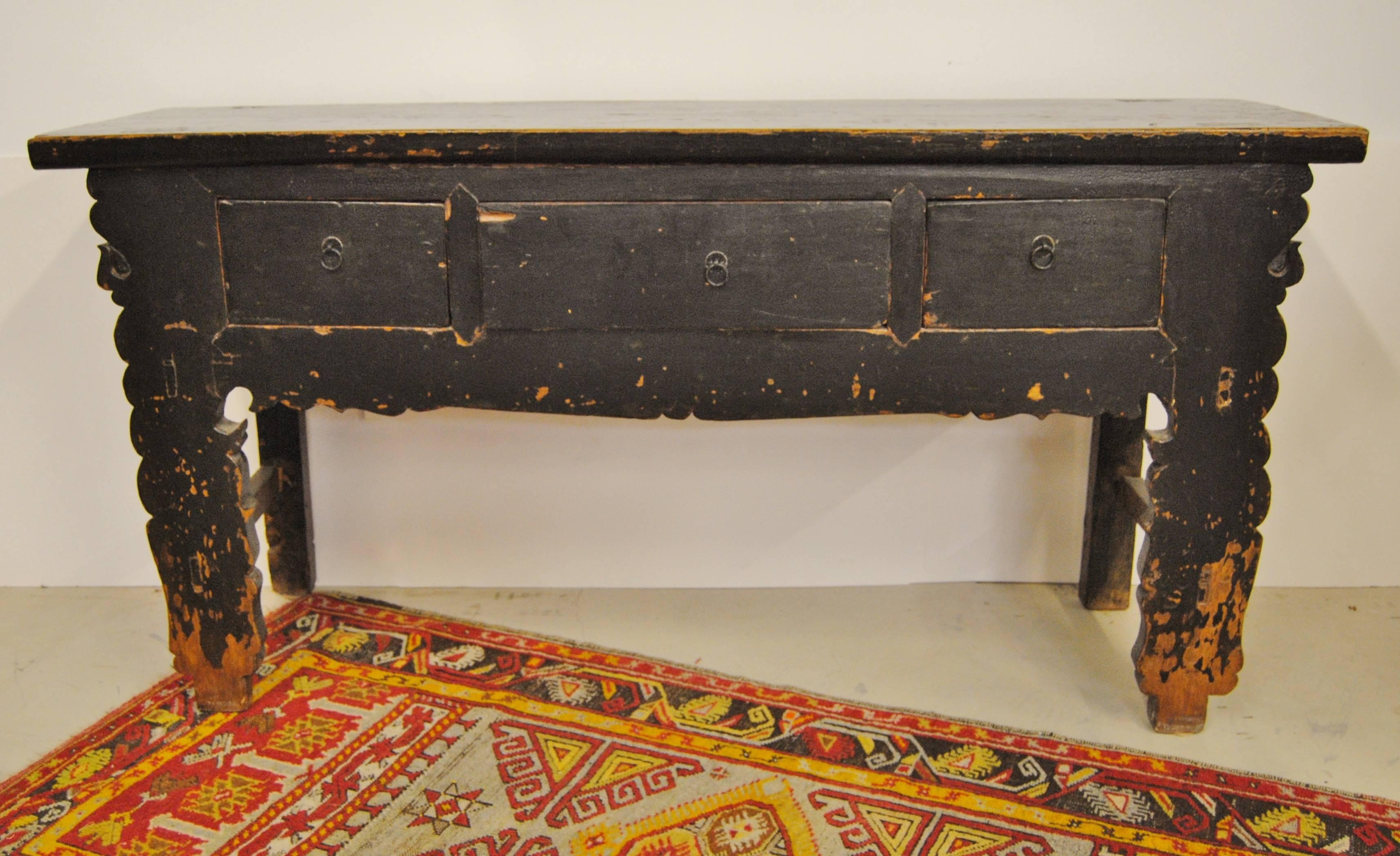 Antique Chinese elmwood sideboard with three drawers from Gansu Province, circa 1900. The Asian table has original lacquer and paint. Scalloped design on the legs adds a whimsical touch. Age appropriate wear on the legs is typical of many country