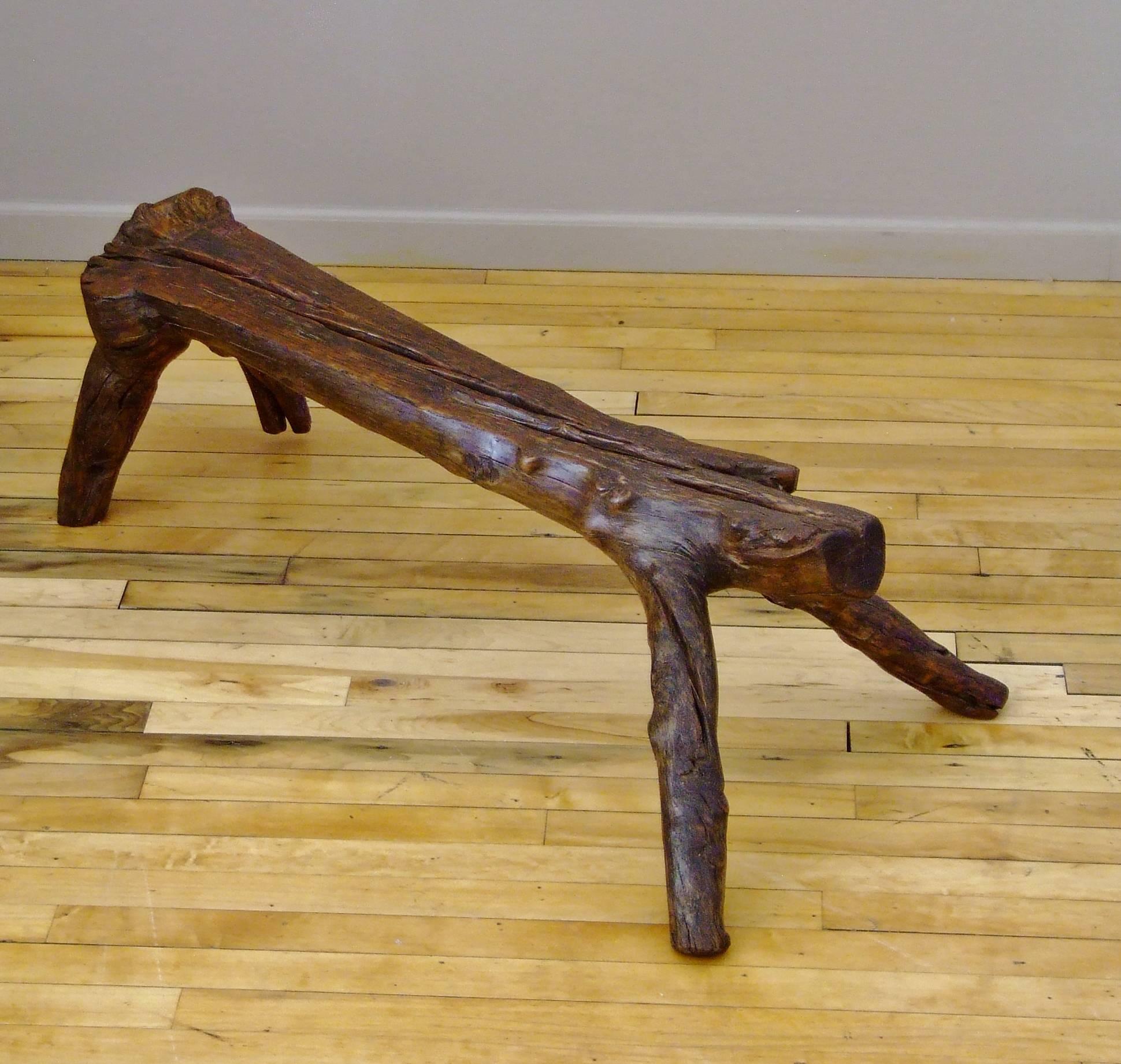 Provincial Chinese low bench formed from the natural branching of elmwood. It resembles the stance of an animal waiting to pounce. A heavy piece that can be used as a bench or footstool and appreciated as an example of Chinese Folk Art.