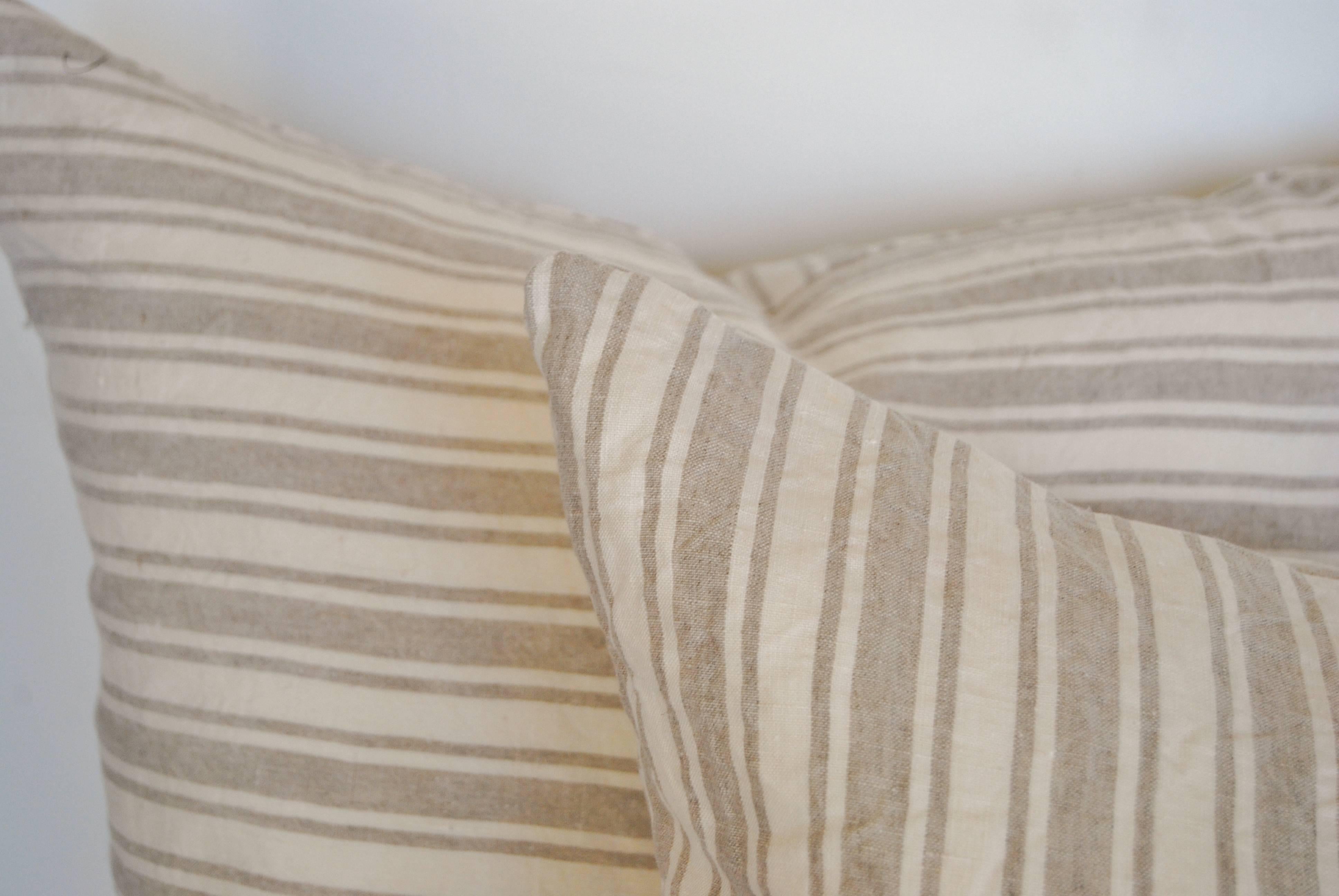 Custom pillows cut from a vintage French linen stripe textile. Stripe is on both sides of pillow. The textile has been freshly laundered and is in it's original wrinkled linen state. The pillows are filled with an insert of 50/50 down and feathers