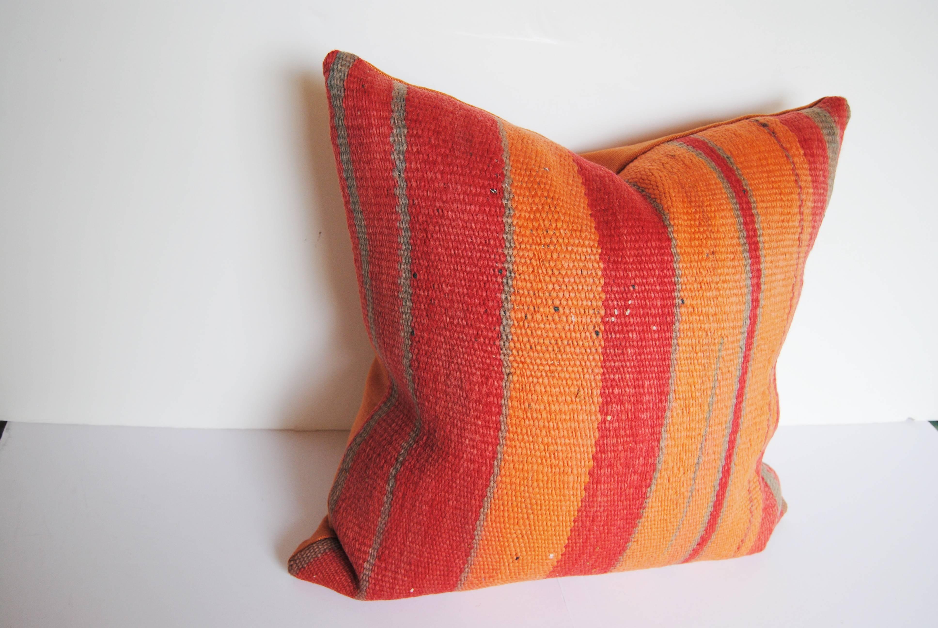 Custom pillows cut from a Vintage hand-loomed wool Moroccan Berber rug from the Atlas Mountains. Textile has strong color with a soft hand. Pillows are backed in shades of apricot and rose linen, filled with an insert of 50/50 down and feathers and