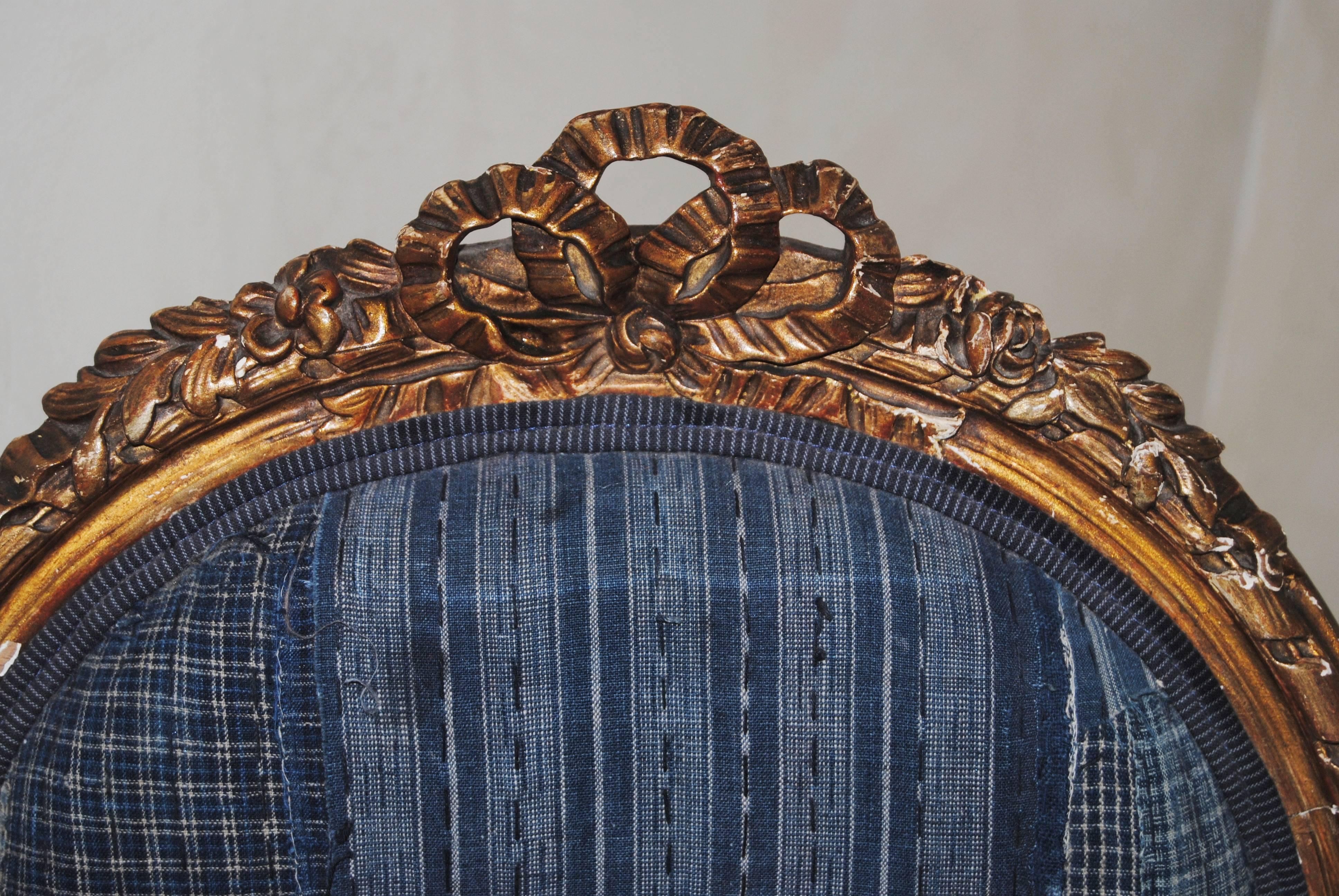 This antique French gilt chair, from late 1800s, was originally upholstered in a fine Aubusson floral textile. The chair has been reupholstered in an antique Japanese indigo boro textile from the late 1800s. The boro is stitched with multiple scraps