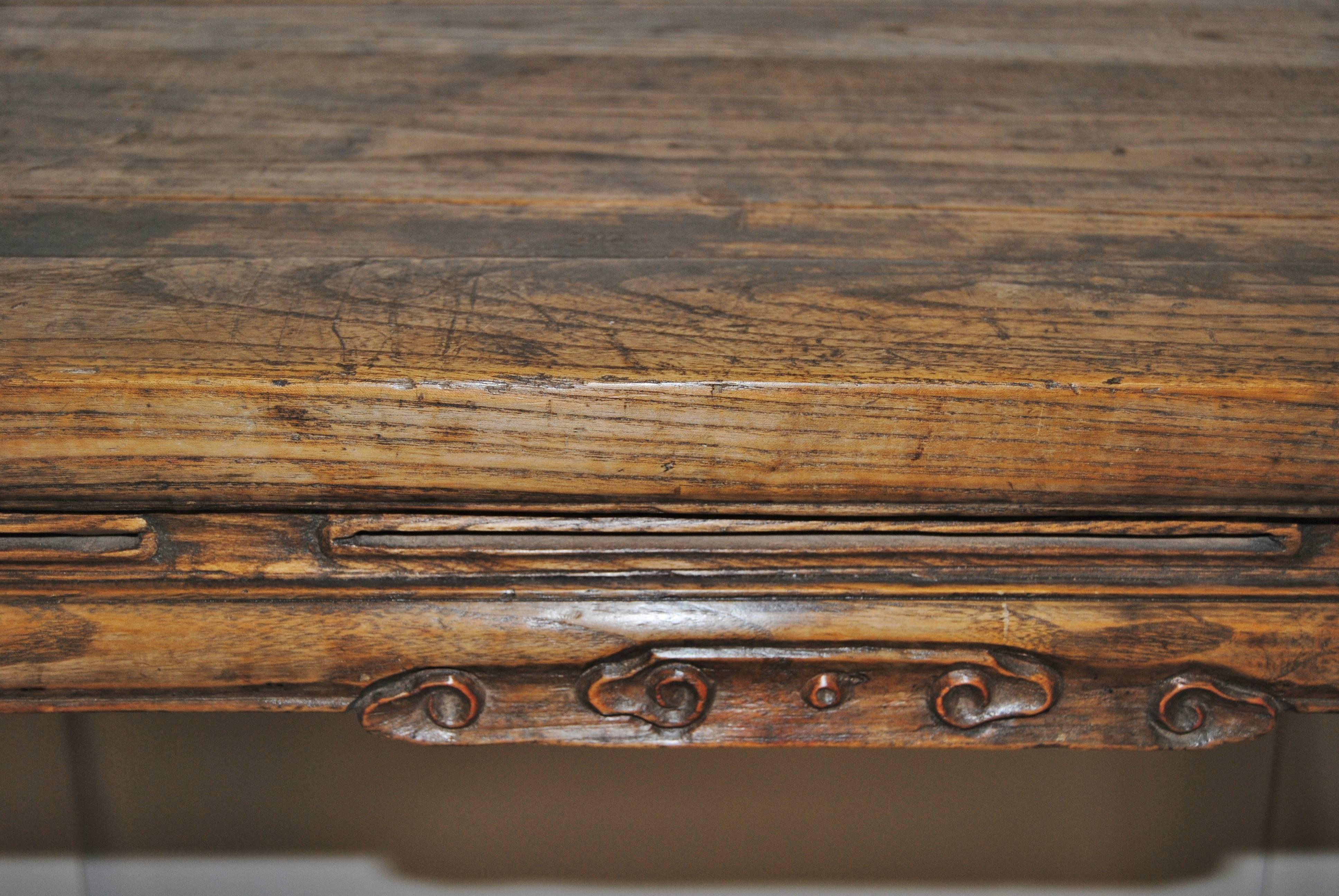 Early 19th century antique Chinese hand-carved elmwood wine table. The Asian piece has original finish with remnants of original lacquer still visible. Beautifully carved openwork detail on rail of table top.