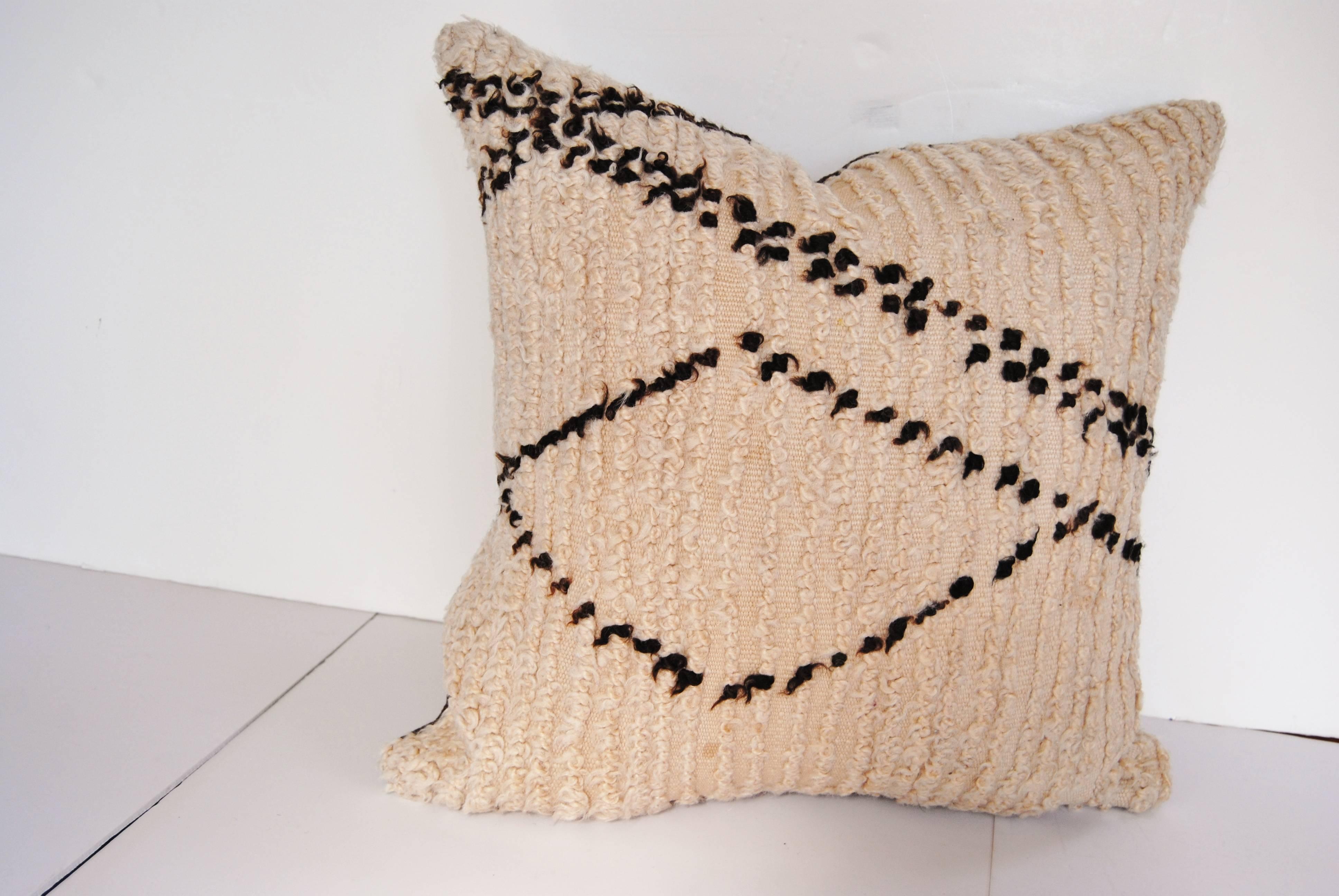Custom pillow cut from a vintage hand loomed wool beni ouarain Moroccan rug from the Atlas Mountains.  Wool is soft and lustrous with all natural color.  Pillow is backed in dark brown linen, filled with an insert of 50/50 down and feathers and hand