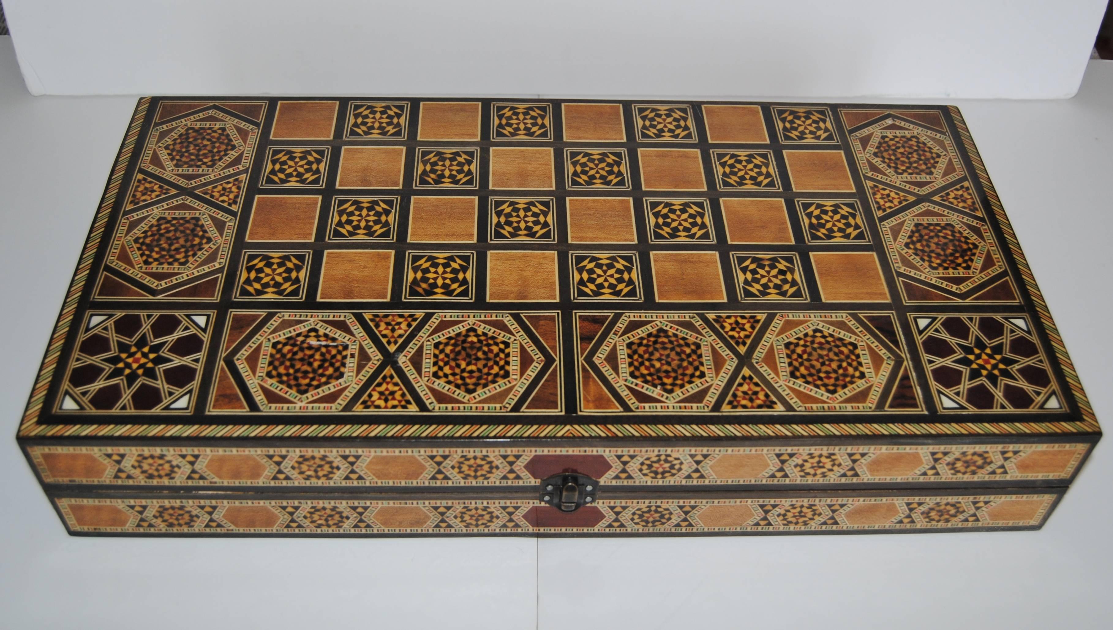 Syrian backgammon/chess board handcrafted from walnut wood inlaid with assorted fruitwoods and mother-of-pearl. Made by traditional Syrian artisans from Damascus, late 20th century. Chess and backgammon pieces included. A treasured piece of Folk