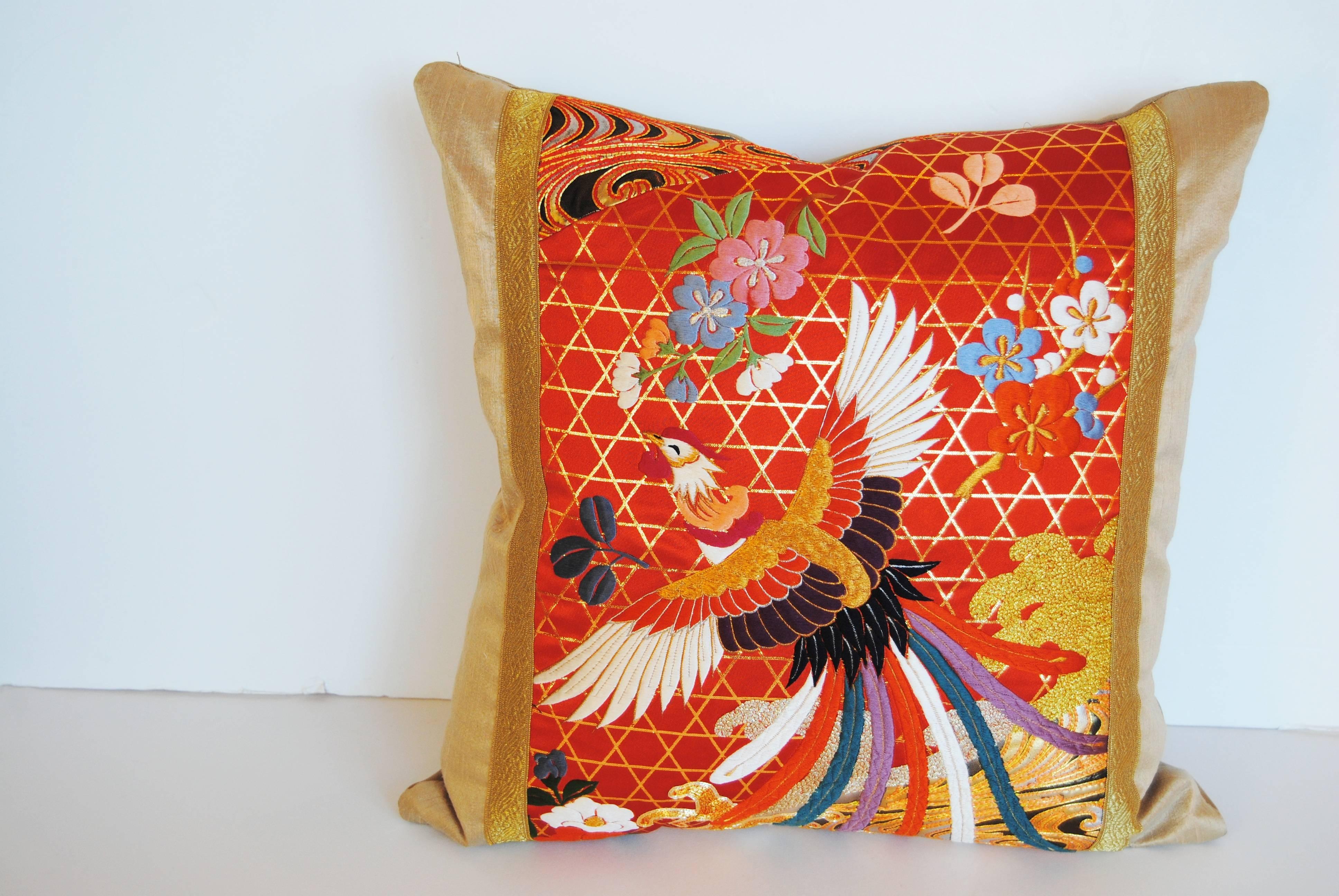 Custom pillow cut from a vintage silk Japanese uchikake wedding kimono. The orange or red silk is embroidered with silk and metallic threads. Pillow is backed in a wool or silk with a facing of cream silk and gold metallic trim. It is filled with an