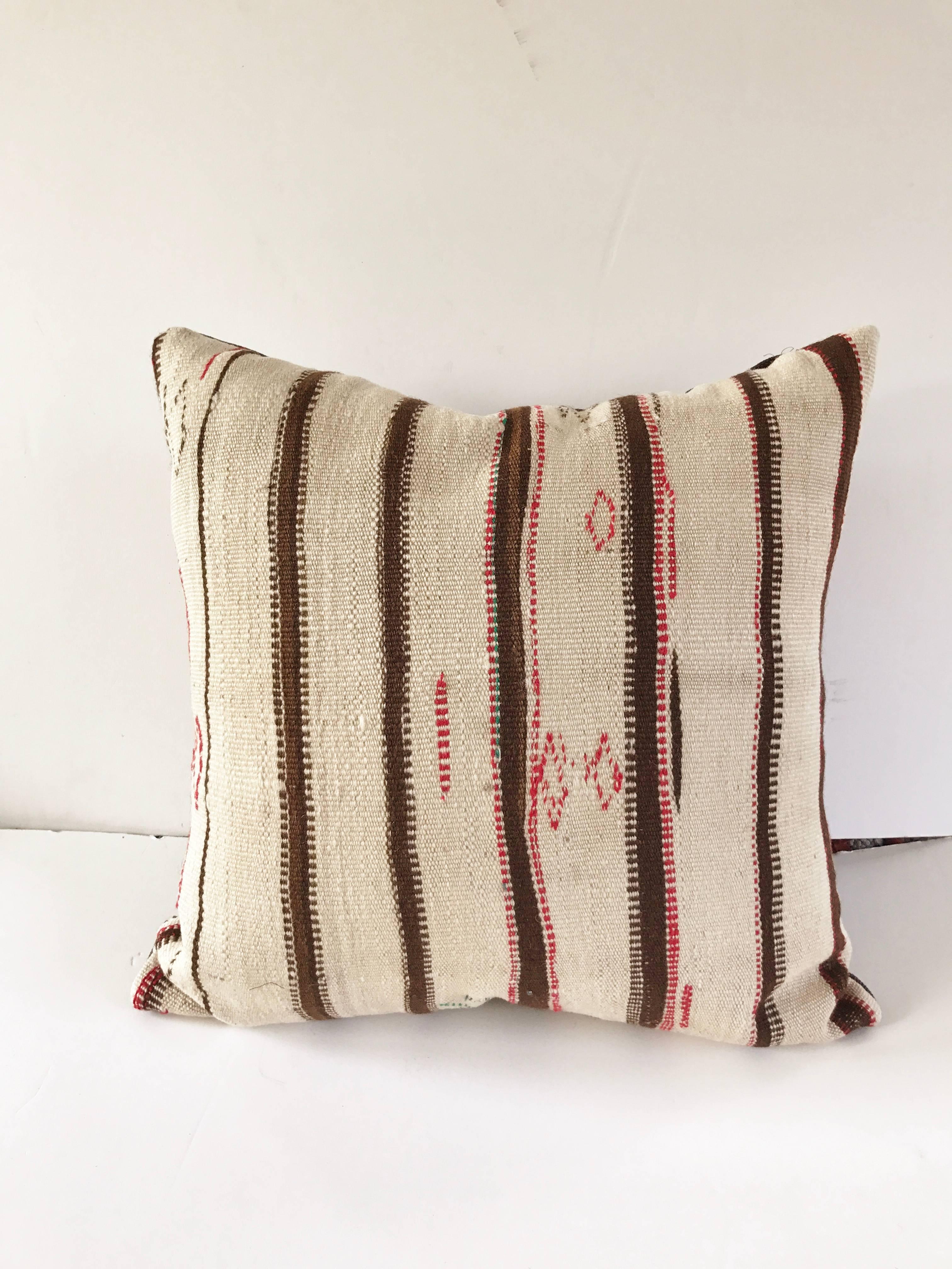 Custom pillow cut from a vintage hand-loomed wool Moroccan Berber rug from the Atlas Mountains. Wool is soft and lustrous with good natural color. Pillow is backed in a dark brown linen blend, filled with an insert of 50/50 down and feathers and