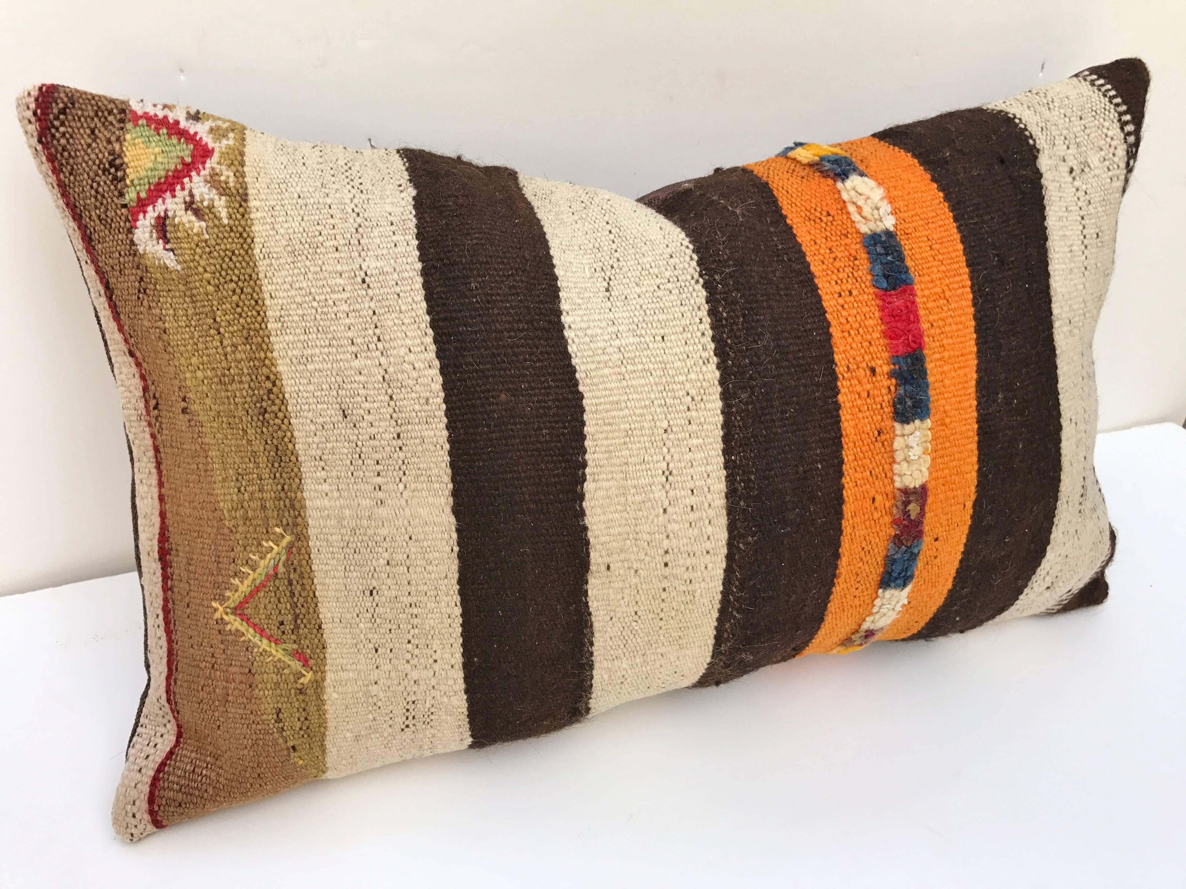 Custom pillow cut from a hnd loomed wool Moroccan Berber rug from the Atlas Mountains. Stripes are embellished with rows of tufted wool. Pillow is backed in a linen blend, filled with an insert of 100% down and hand sewn closed. All custom pillows