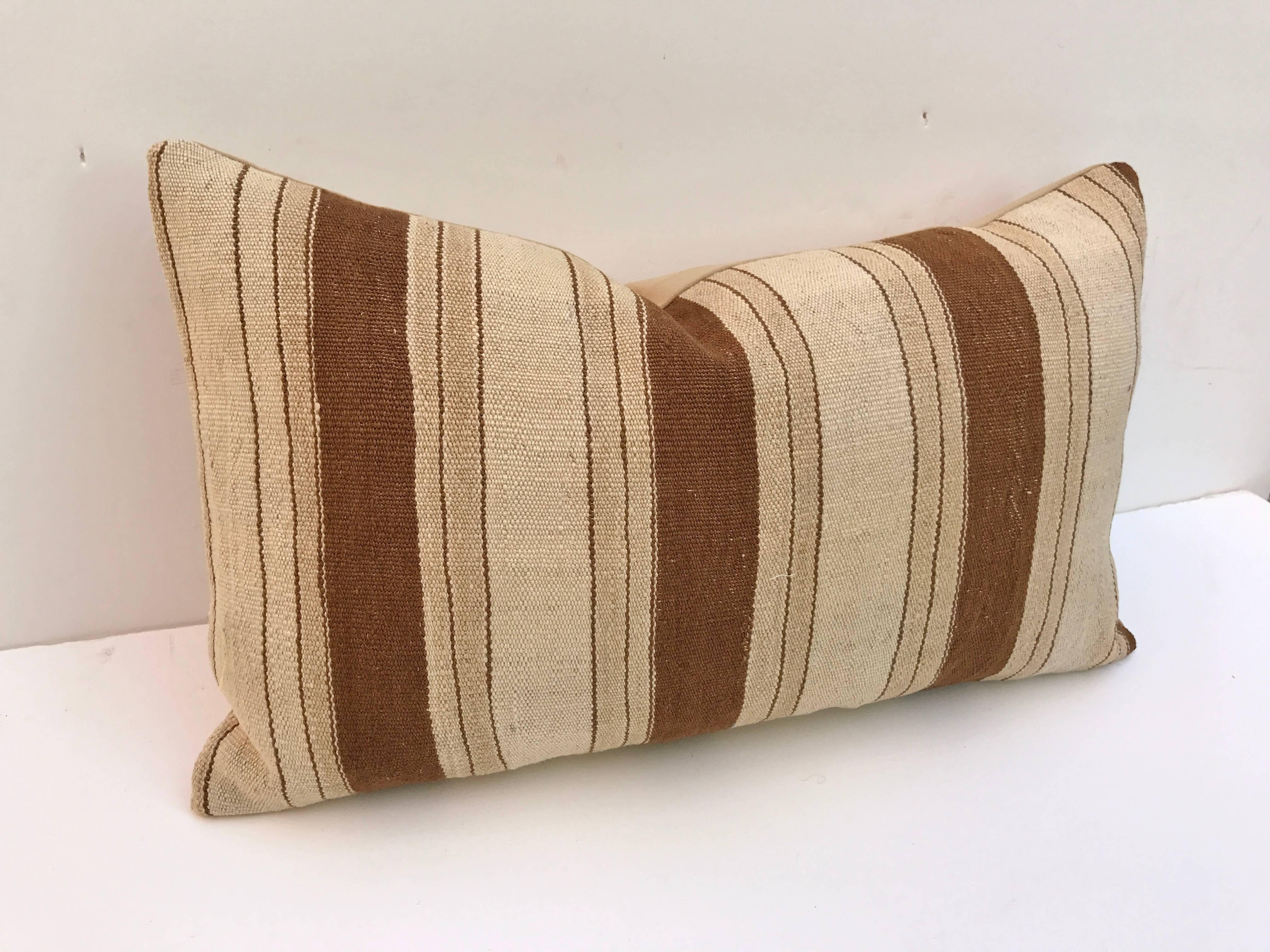 Custom pillow cut from a vintage hand loomed wool Moroccan Berber blanket from the Atlas mountains. Wool is soft and lustrous with natural colors. Pillow is backed in a wool blend, filled with an insert of 50/50 down and feathers and hand-sewn