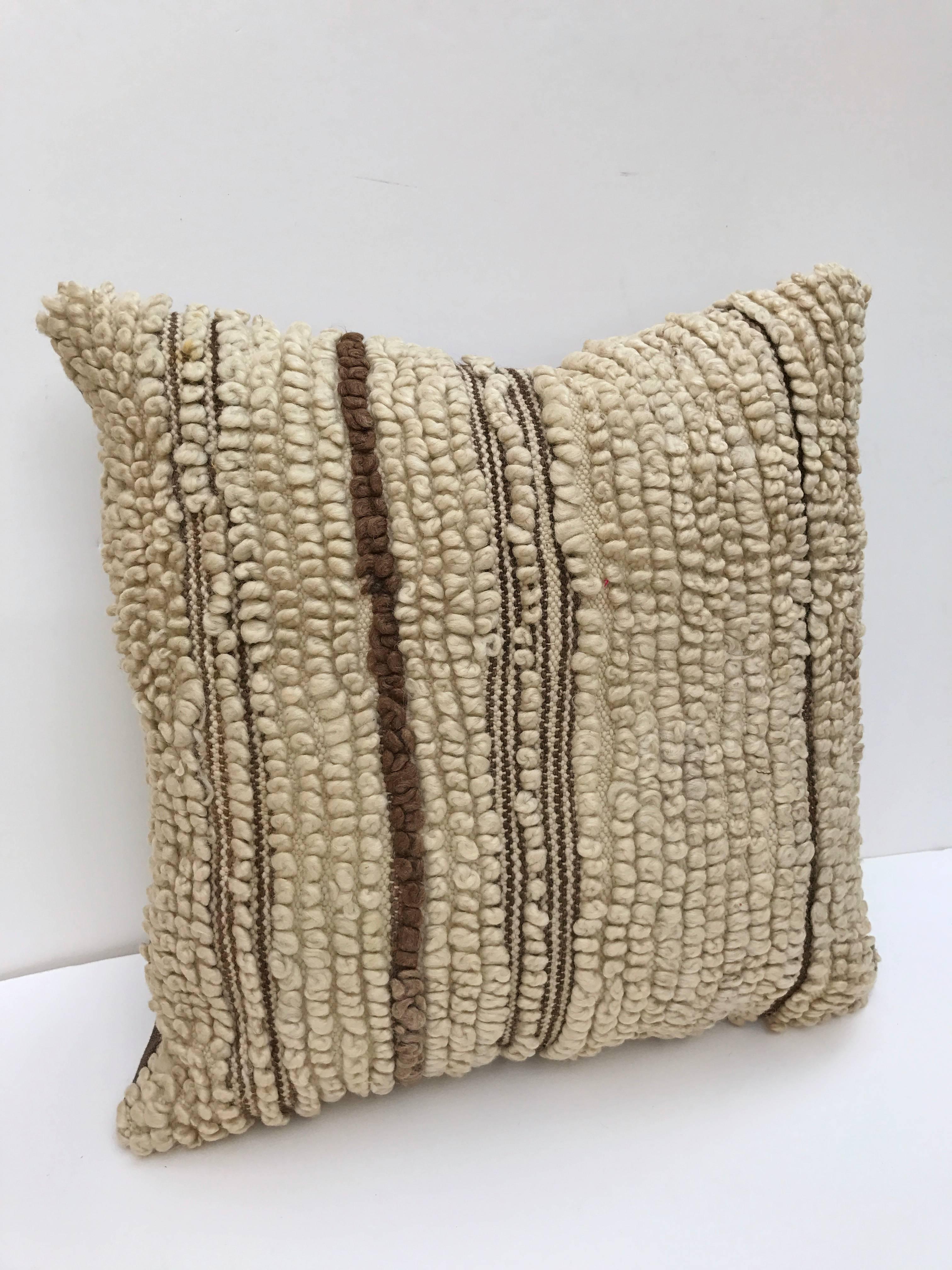Custom pillow cut from a vintage hand loomed wool Moroccan Beni Ouarain rug from the Atlas Mountains. Wool is soft and lustrous with natural colors. Pillow is backed in linen, filled with an insert of 50/50 down and feathers and hand-sewn closed.