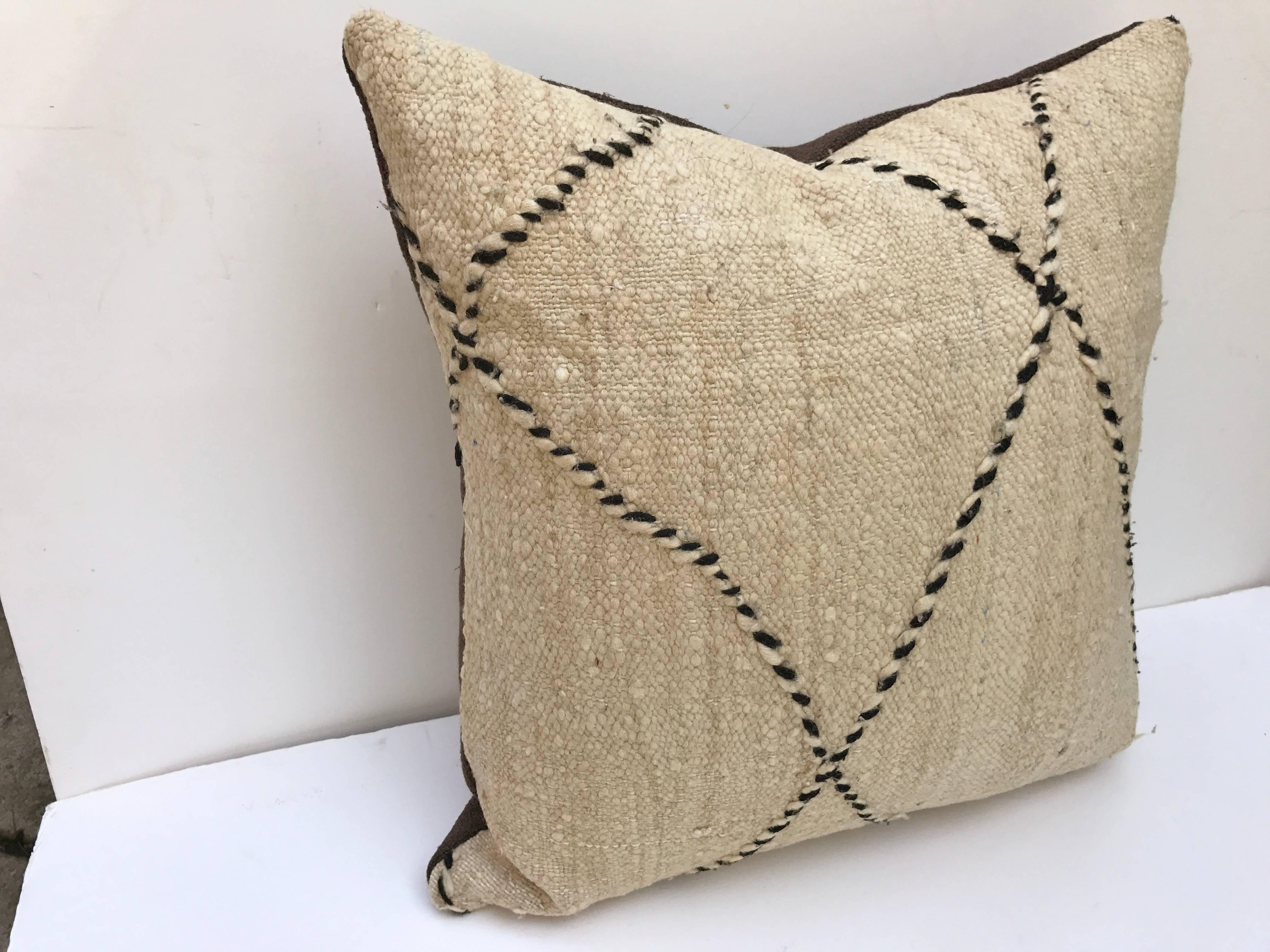 Custom pillow cut from a vintage hand-loomed wool Moroccan Beni Ouarain rug from the Atlas Mountains. Wool is soft and lustrous with natural color. Pillow is backed in brown linen blend, filled with an insert of 50 / 50 down and feathers and