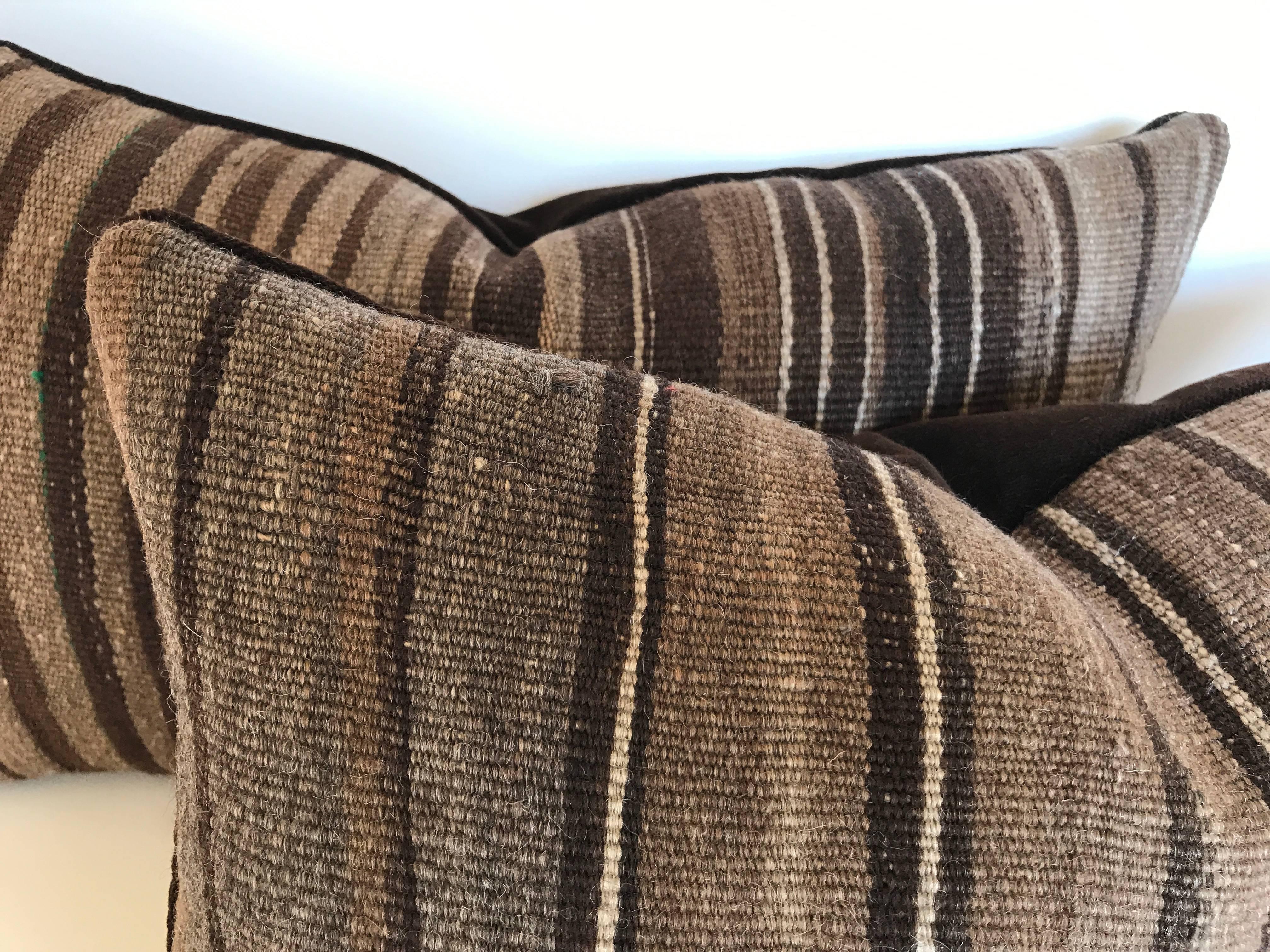 Custom pillows cut from a vintage hand-loomed wool Moroccan Berber rug from the Atlas Mountains. Wool is soft and lustrous with all natural colors in shades of brown. Pillows are backed in dark brown velvet, filled with an insert of 50/50 down and