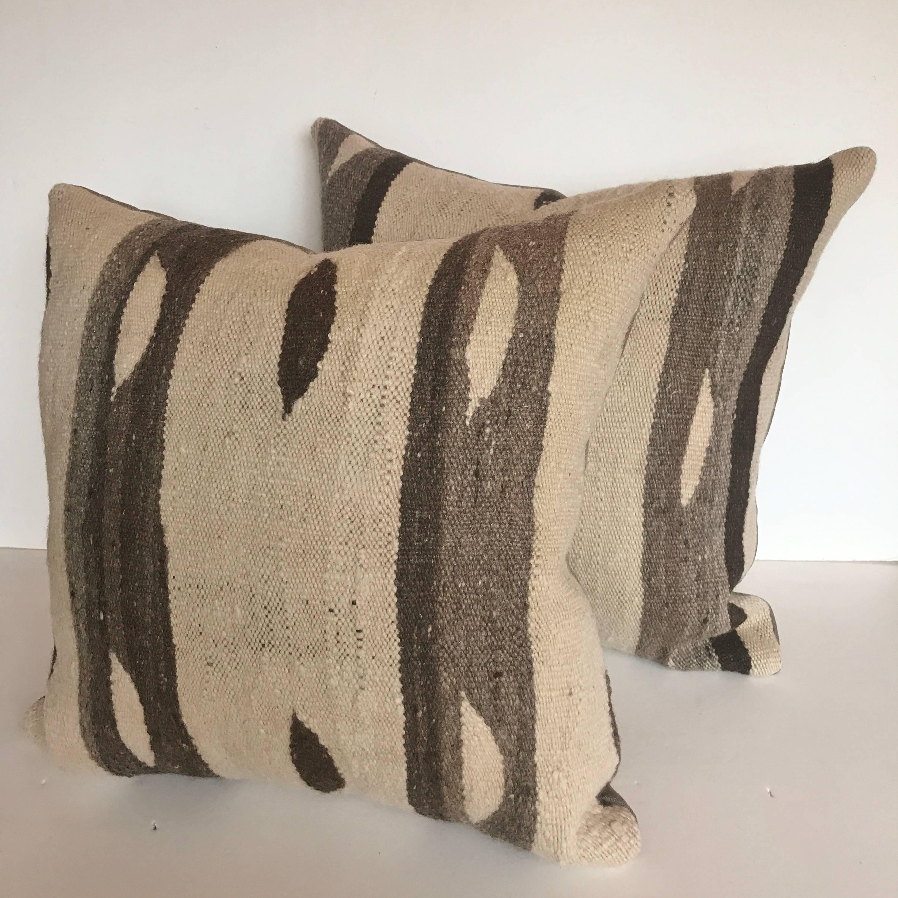 Custom pair of pillows cut from a vintage hand loomed wool Moroccan Ourika Berber rug, High Atlas Mountains. Wool is soft with natural color. Pillows are backed in linen, filled with an insert of 50/50 down and feathers and hand-sewn closed. All