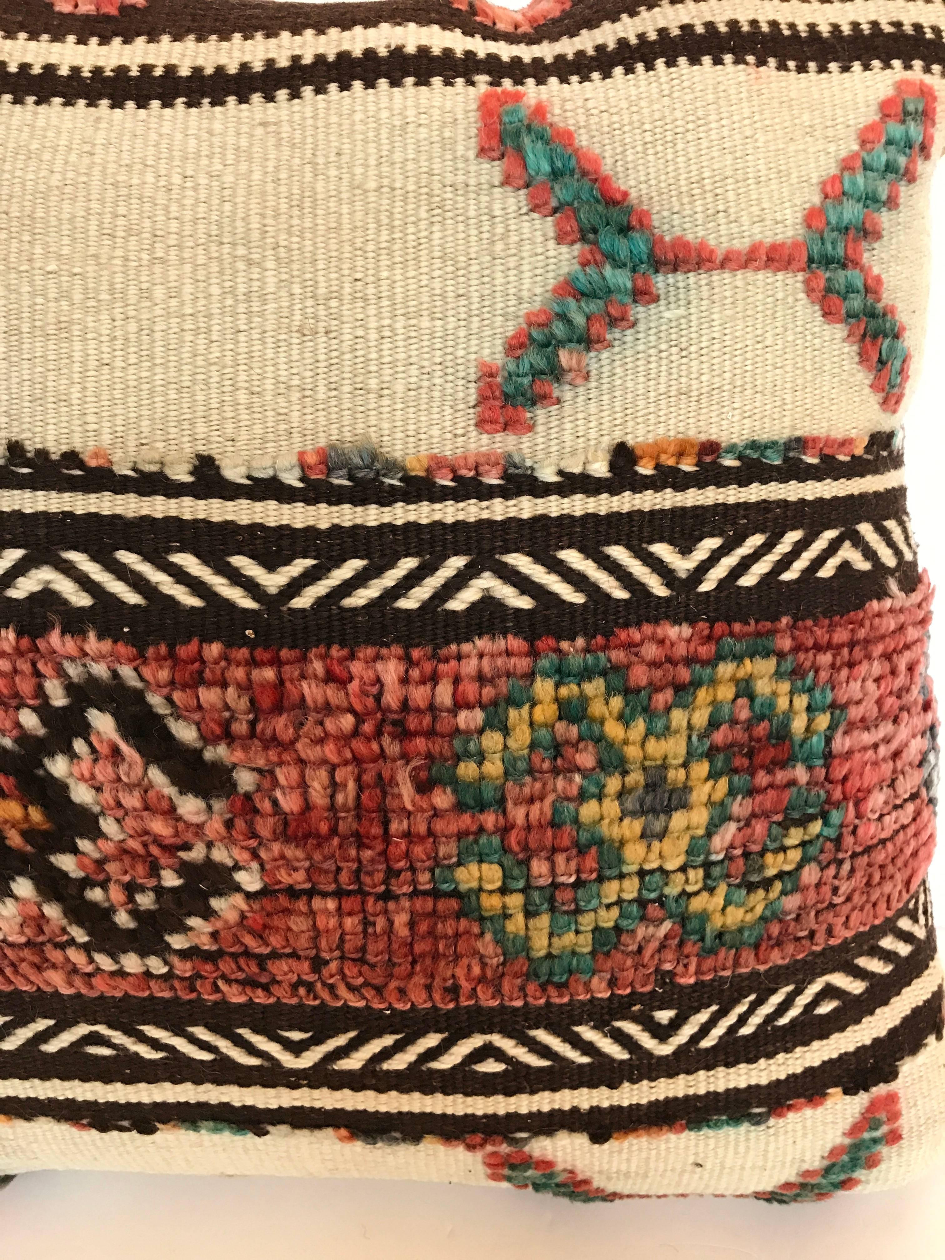 Custom pillow cut from a vintage hand loomed wool Moroccan rug made by the Berber tribes of the Atlas Mountains.  Wool is soft and lustrous with all natural dyes.  The flat weave textile is embellished with woven tufted tribal designs.  The pillow