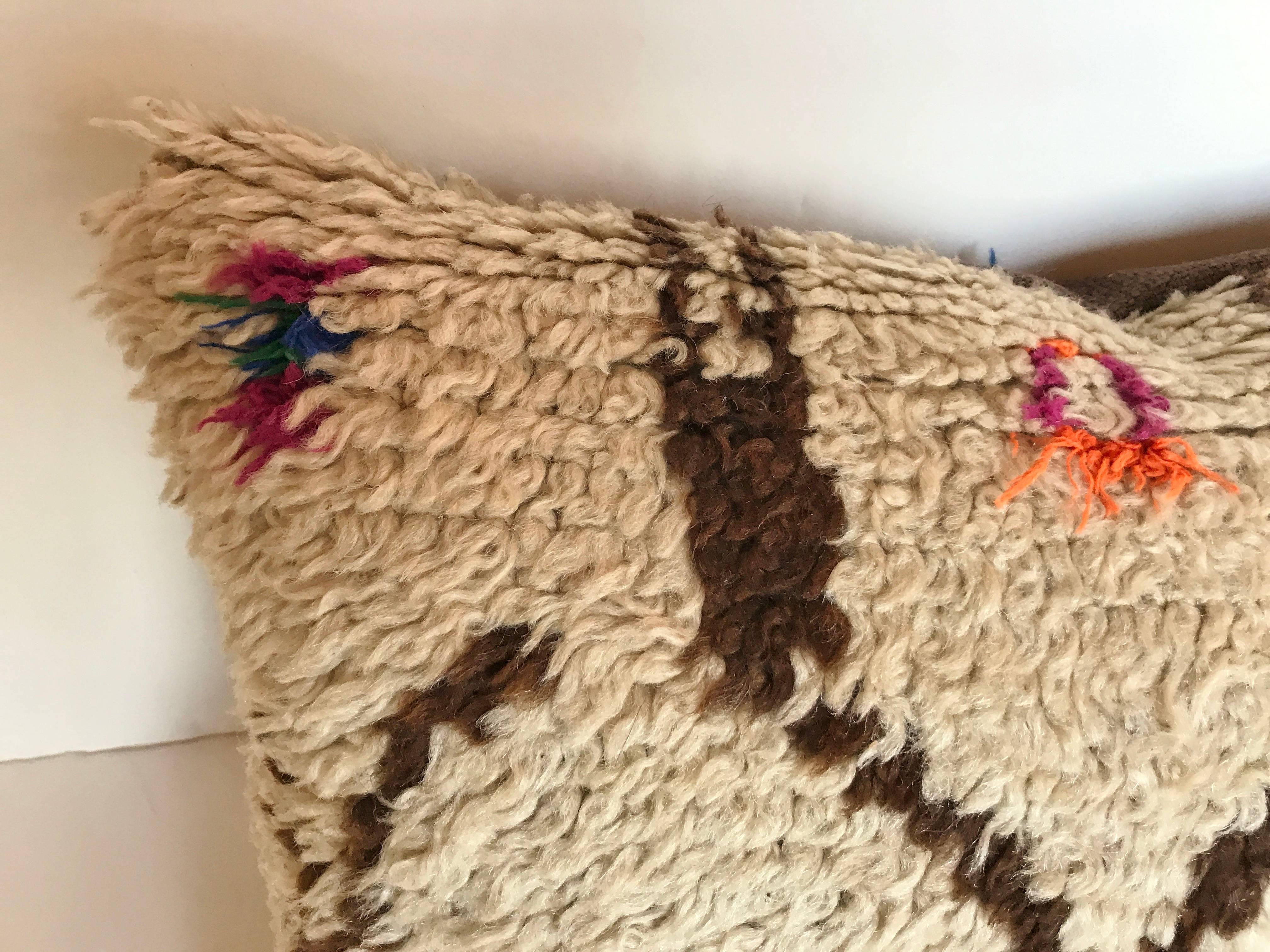Custom pillow cut from a vintage hand loomed wool Moroccan Azilal rug made by the Berber tribes of the Atlas Mountains.  Wool is soft and lustrous.  Pillow is filled with an insert of 50/50 down and feathers, backed in a linen blend and hand sewn