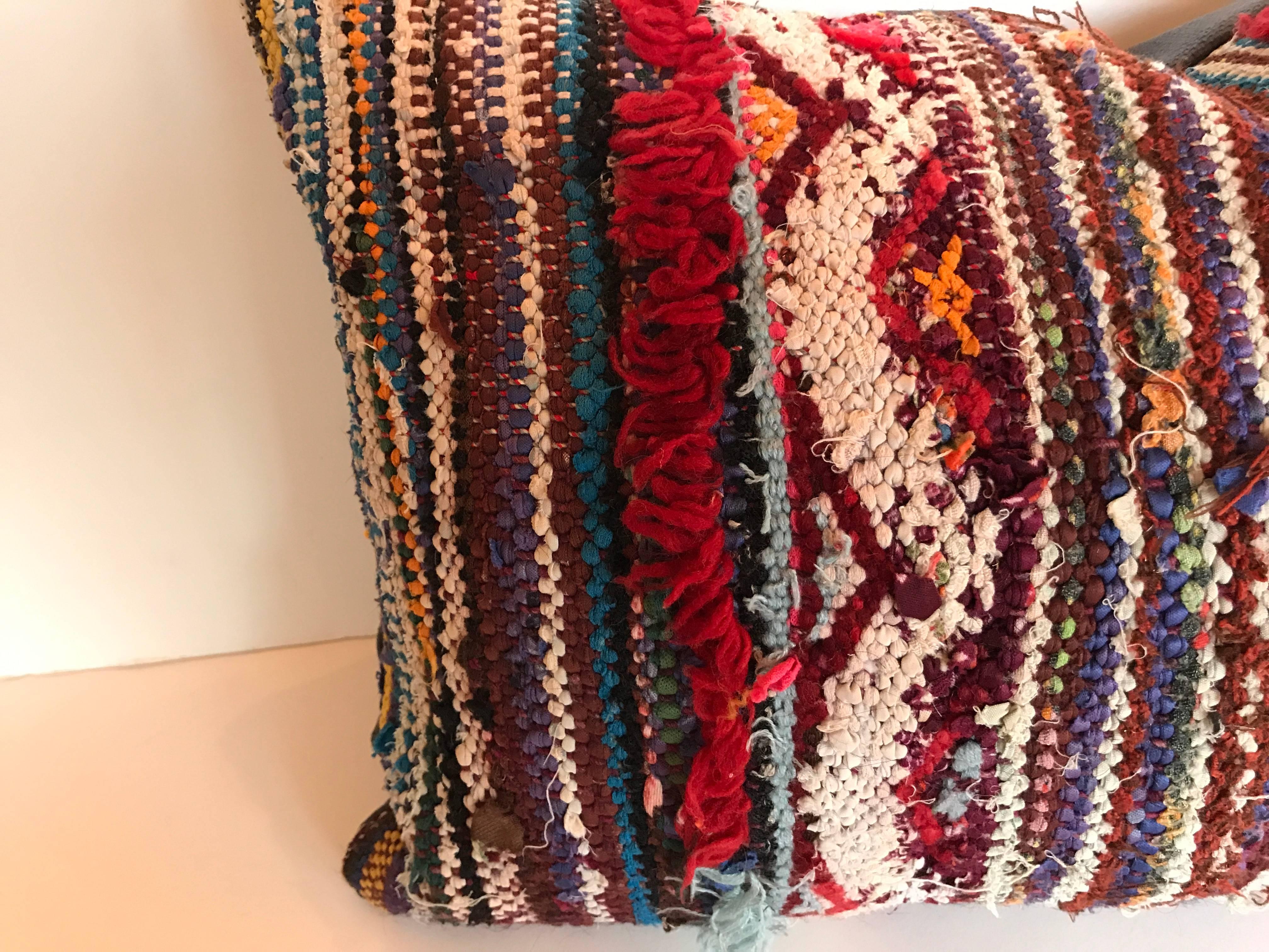 Custom pillow cut from a vintage Moroccan Berber boucherouite hand loomed rug from the Atlas Mountains. The wool and cotton flat weave rug is embellished with tribal embroidered and tufted designs. Pillow is backed in linen, filled with an insert of