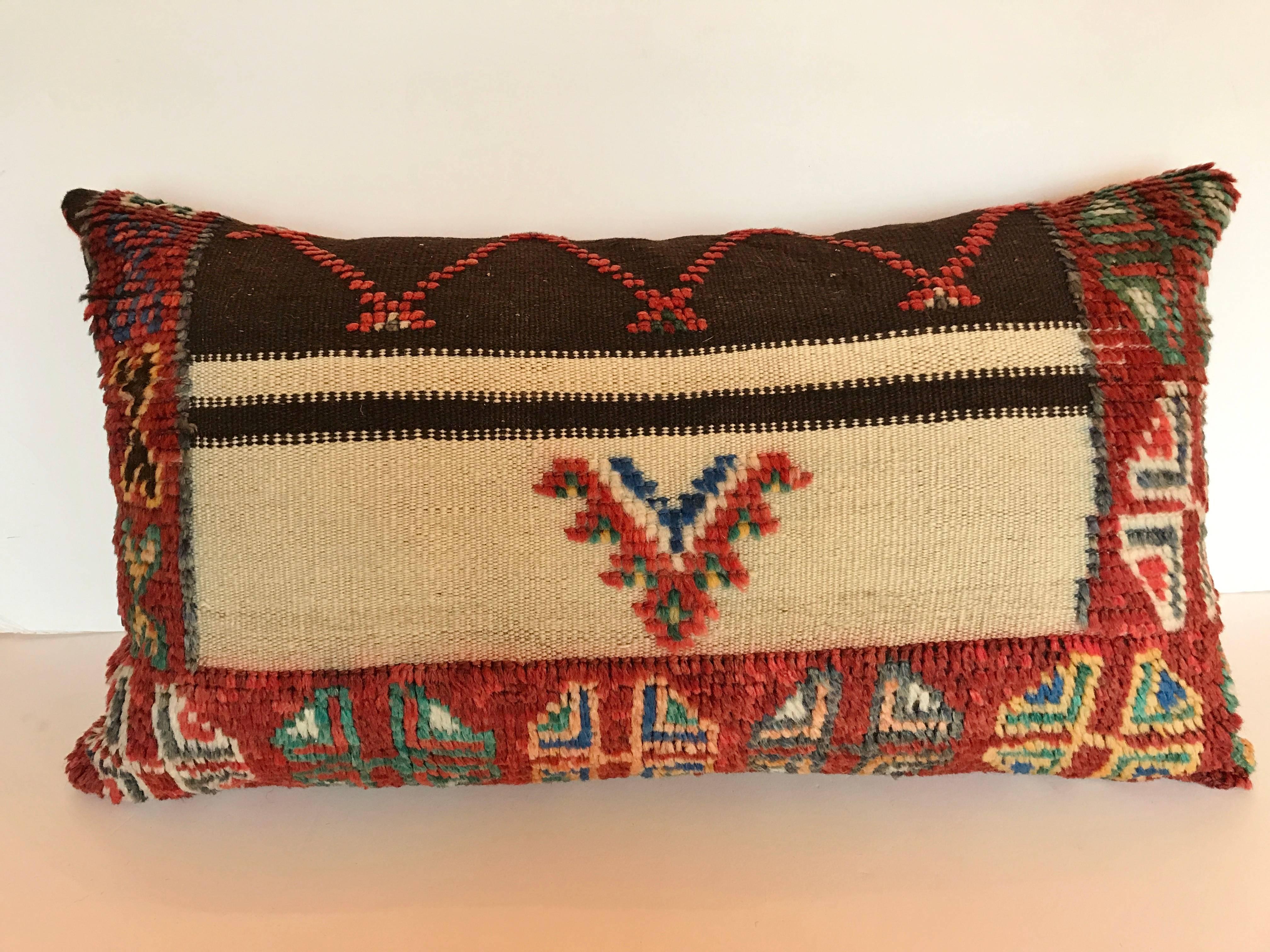 Custom pillow cut from a vintage hand loomed wool Moroccan rug made by the Berber tribes or the Atlas Mountains.  Wool is soft and lustrous with all natural dyes.  Pillow is backed in velvet, filled with an insert of 100% down and hand sewn closed. 
