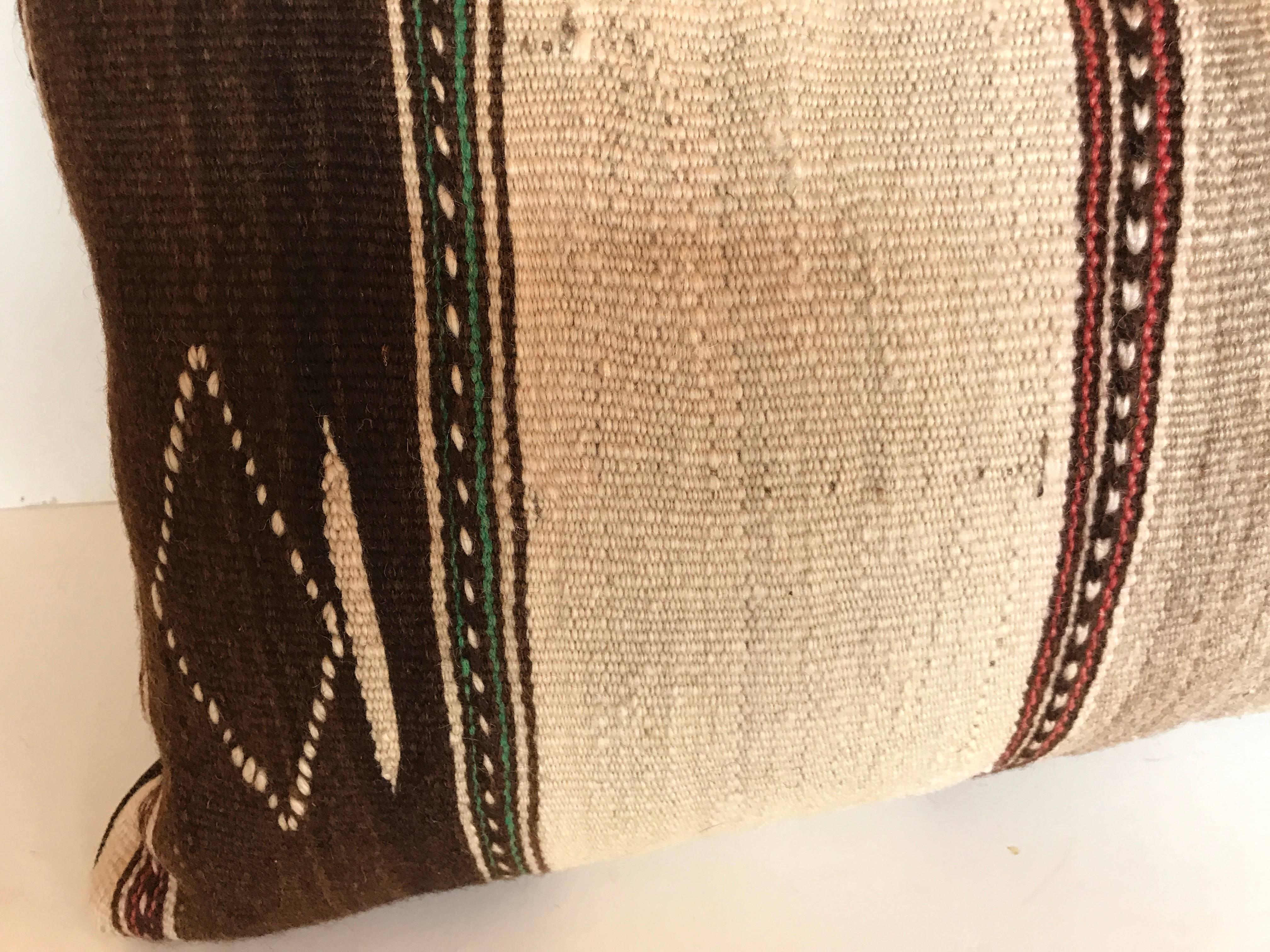 Custom pillow cut from a vintage hand loomed wool Moroccan Ourika rug made by the Berber tribes of the Upper Atlas Mountains.  Wool is soft and lustrous with natural colors.  Pillow is backed in a linen blend, filled with an insert of 100% down and