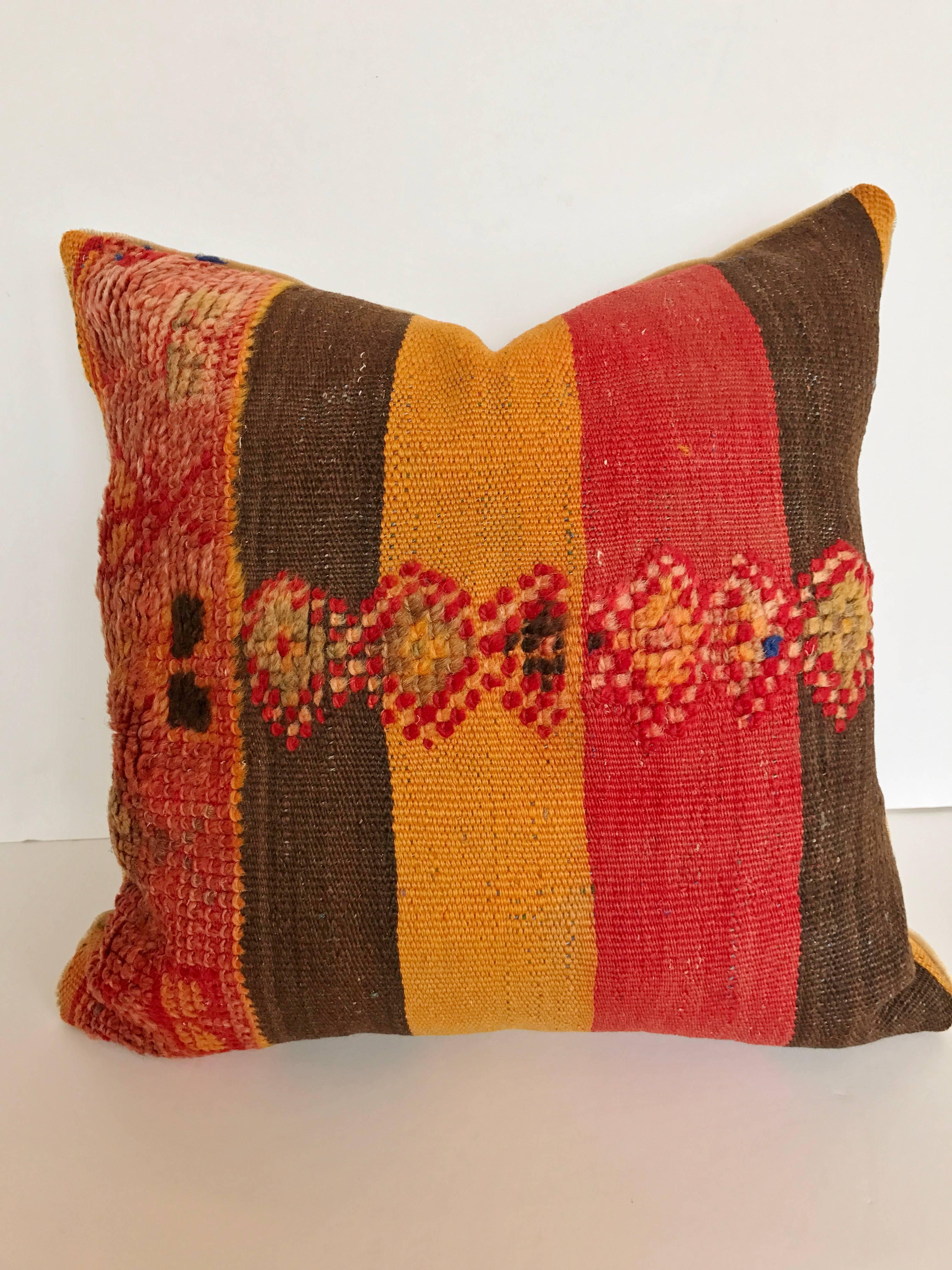 Custom pillow cut from a vintage hand loomed wool and goat hair Moroccan Berber rug from the Atlas Mountains. This is an older piece with tightly woven flat-weave stripes and wool tufted tribal designs. Pillow is backed in mohair, filled with an