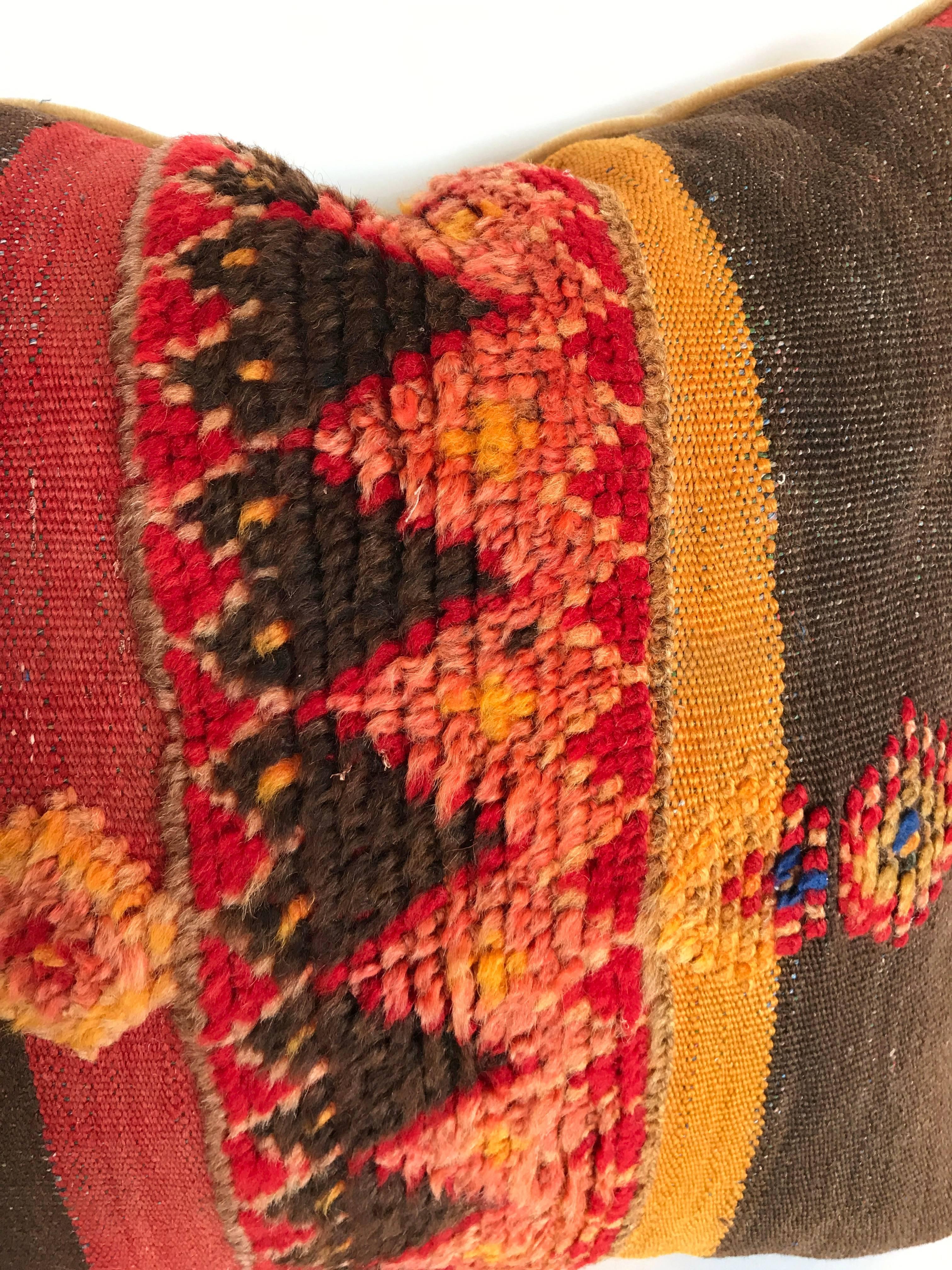 Custom pillow cut from a vintage hand loomed wool and goat hair Moroccan Berber rug from the Atlas Mountains. This is an older piece with tightly woven stripes and tufted wool tribal designs. Pillow is backed in mohair, filled with an insert of