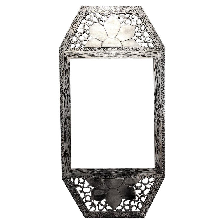 
French Art Deco wrought iron mirror with intricate scrolls of flower motif. The frame has been replated in nickel with a black patina (can be removed) by request. The mirror can be used horizontally or vertically. Including a new beveled mirror. We