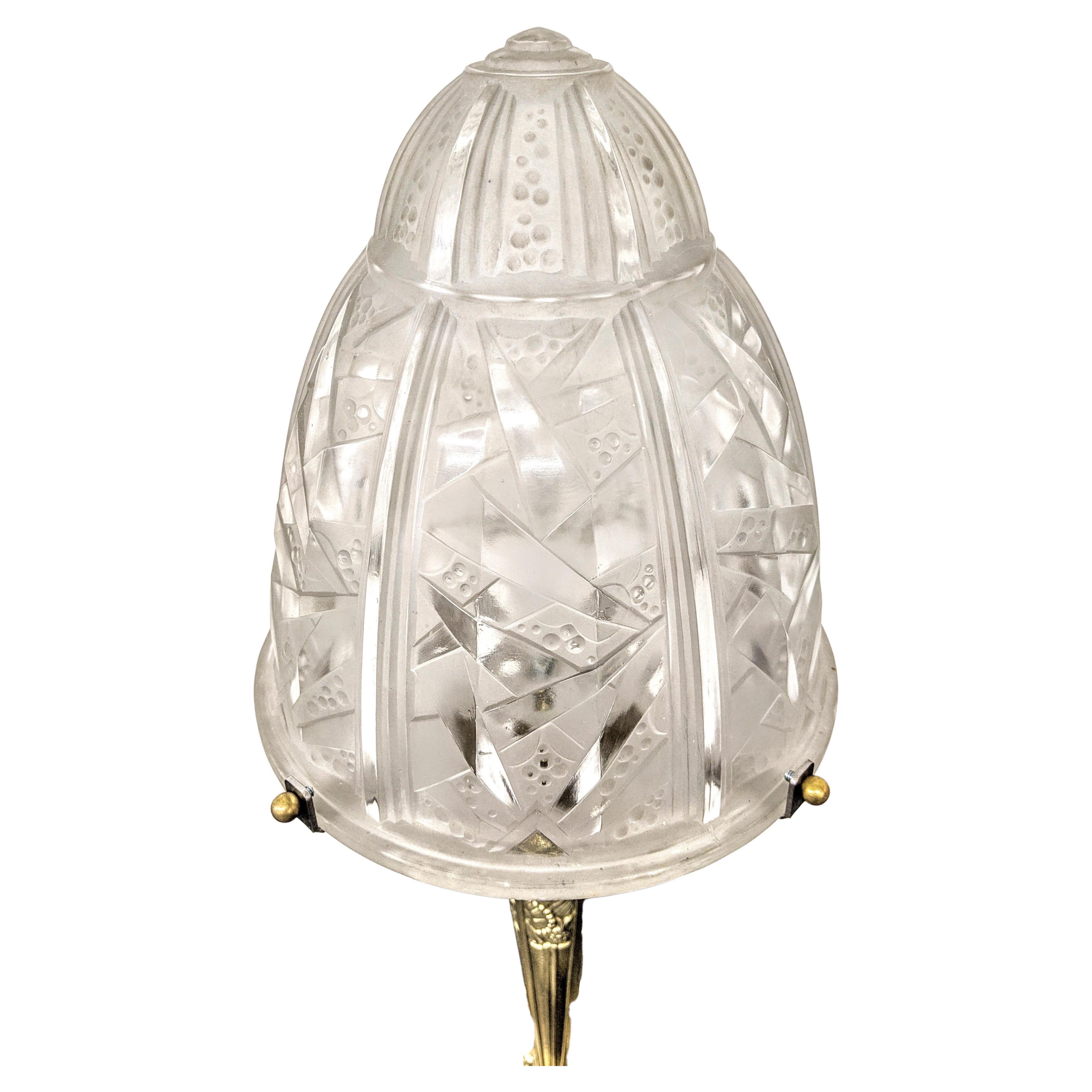 A stunning pair of French Art Deco table lamps were created by Muller Frères in great condition. Each shade is enhanced by a typical French Art Deco geometric motif in frosted glass with polished details. Mounted on a Bronze with flowers and a