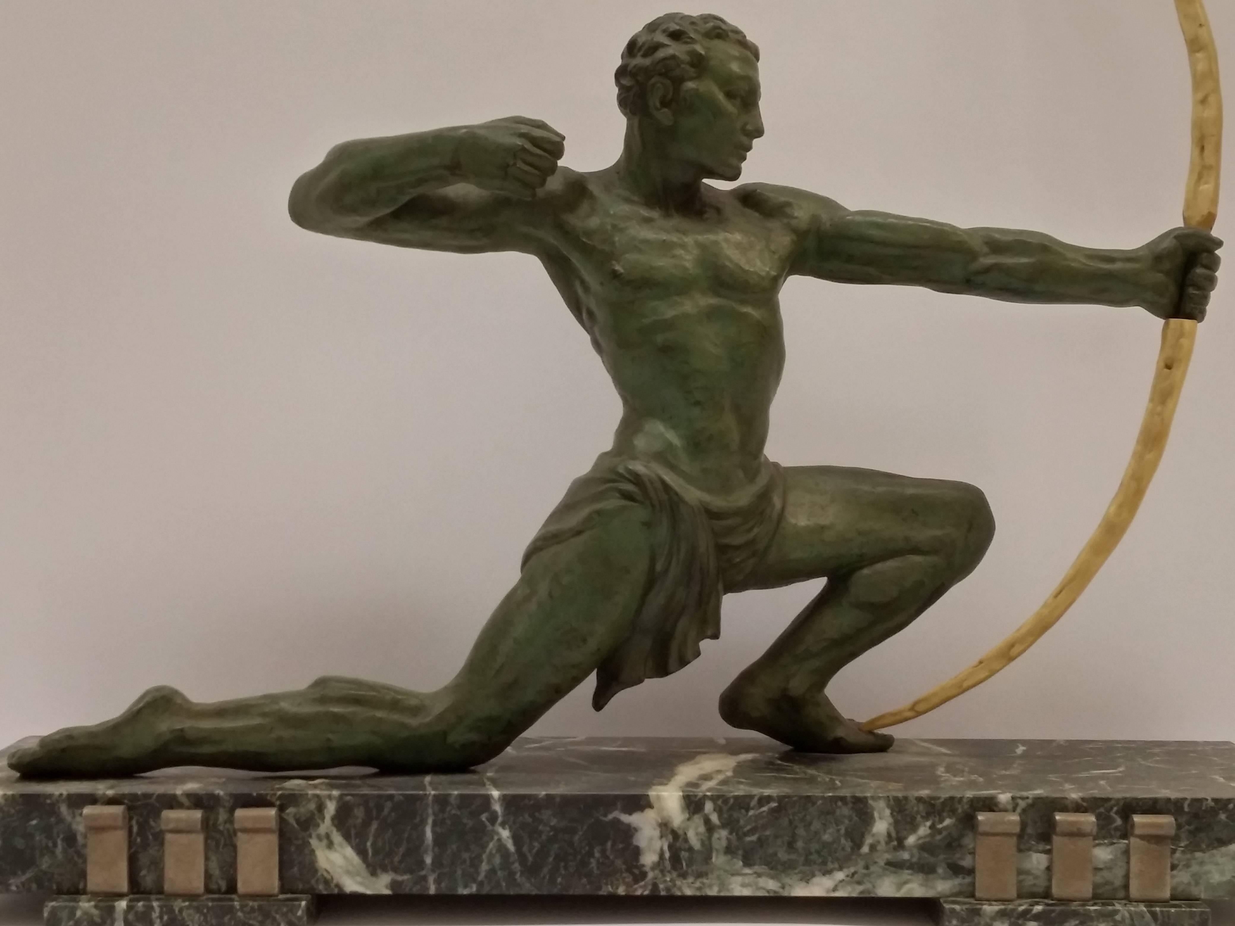 French Art Deco Hunter with a bow in light green patina in perfect condition. The sculpture rests on a green with white veined marble base with metal details.