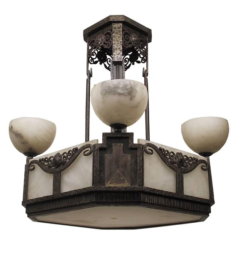 Questo eccezionale e importante lampadario francese Art Déco di forma quadrata. Ferro battuto forgiato a mano in diverse texture con motivi intricati di foglie e fiori. Paralumi originali a pannello rettangolare in alabastro piatto con quattro