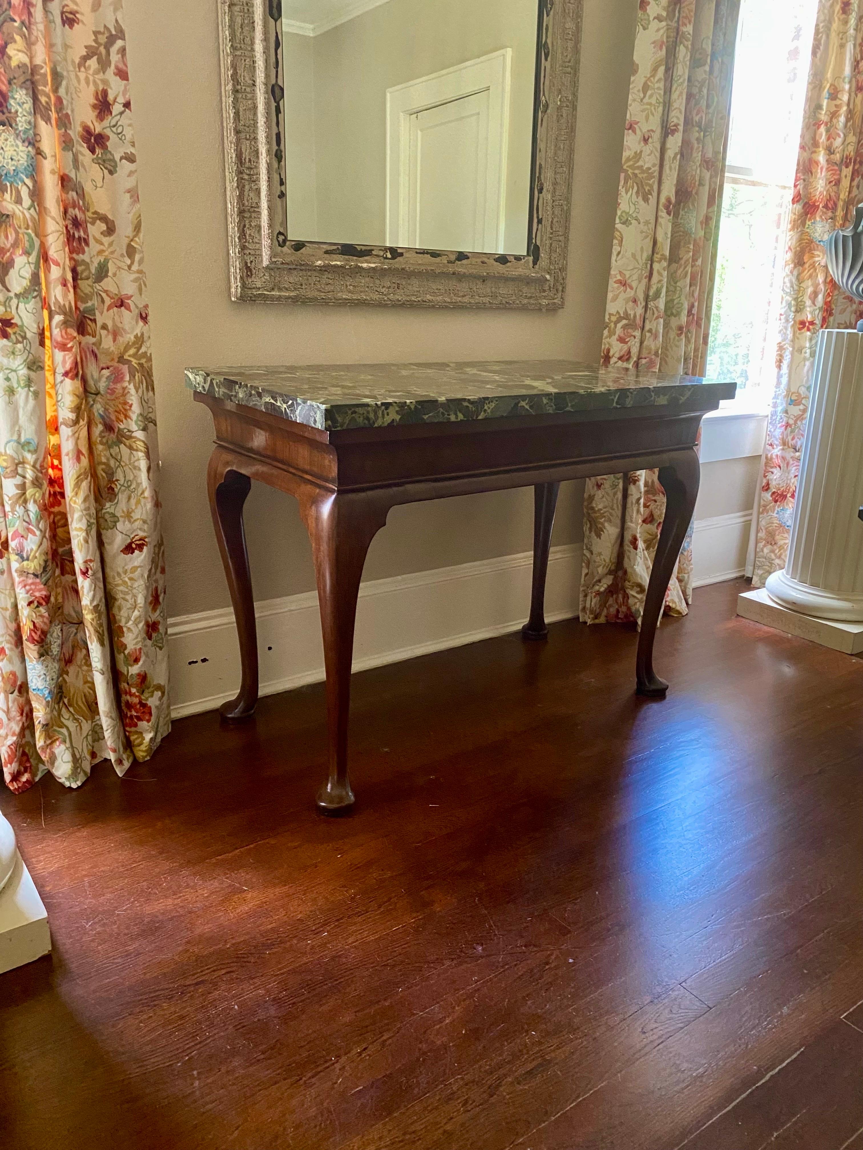 Wonderful George II period center table, circa 1740, with associated marble top. Beautifully veneered green marble top is supported by a walnut base with a cavetto modeled frieze veneered in walnut, supported by tapering cabriole legs terminating in