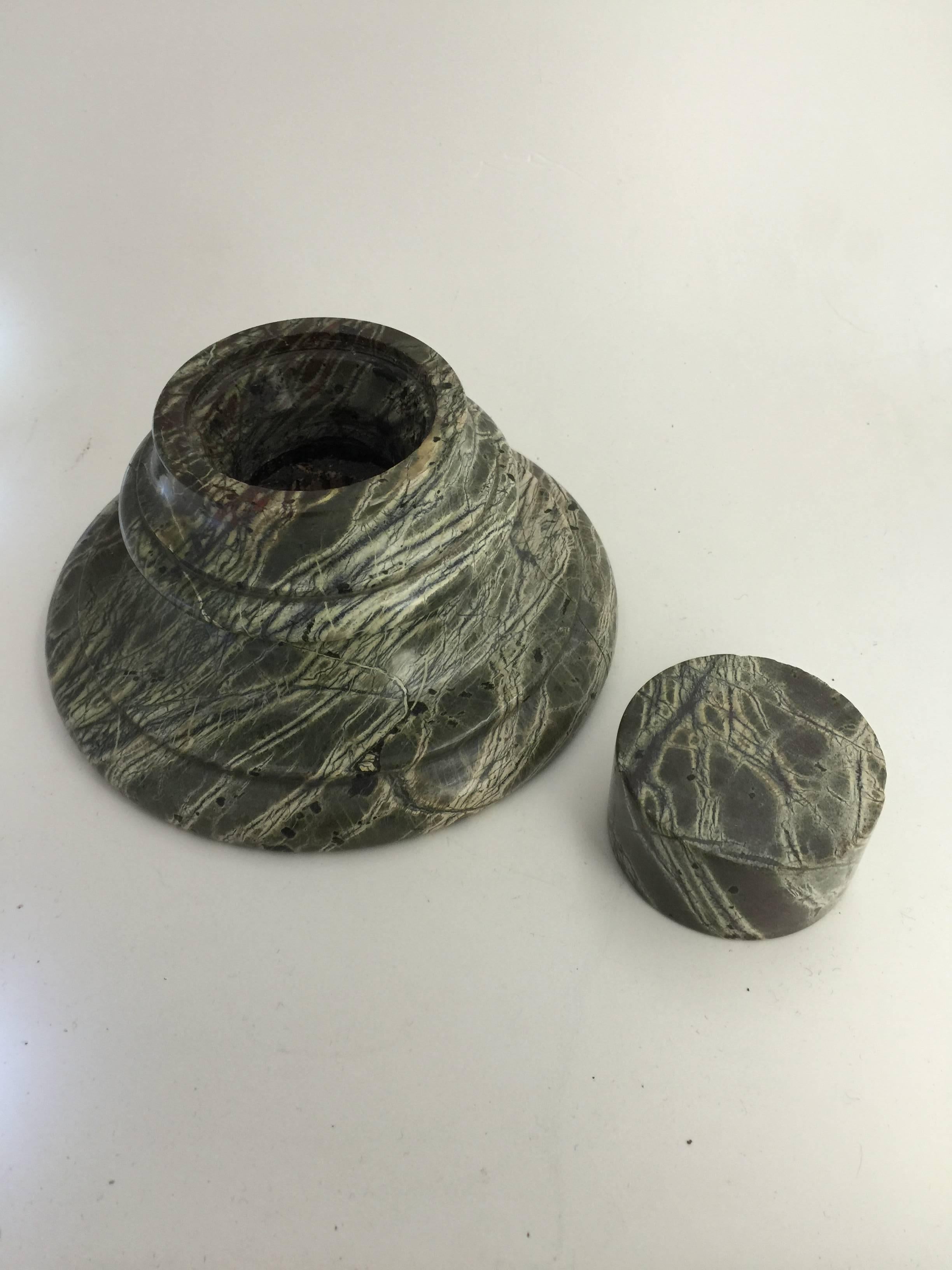 A gray marble circular inkwell with marble stopper.