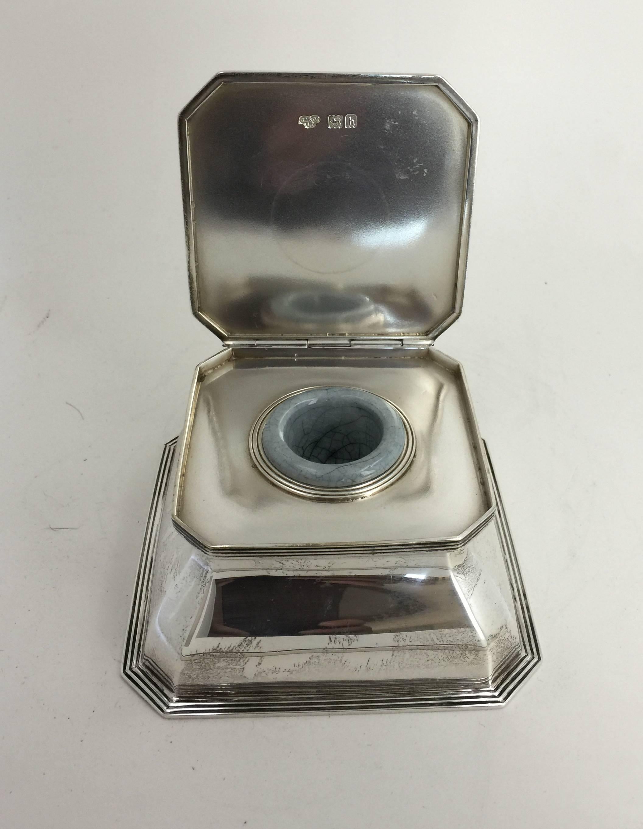 The rectangular inkwell with flat hinged lid, opening to reveal ceramic well and cut-glass liner beneath. Hallmarks on inside cover, rear and underside.