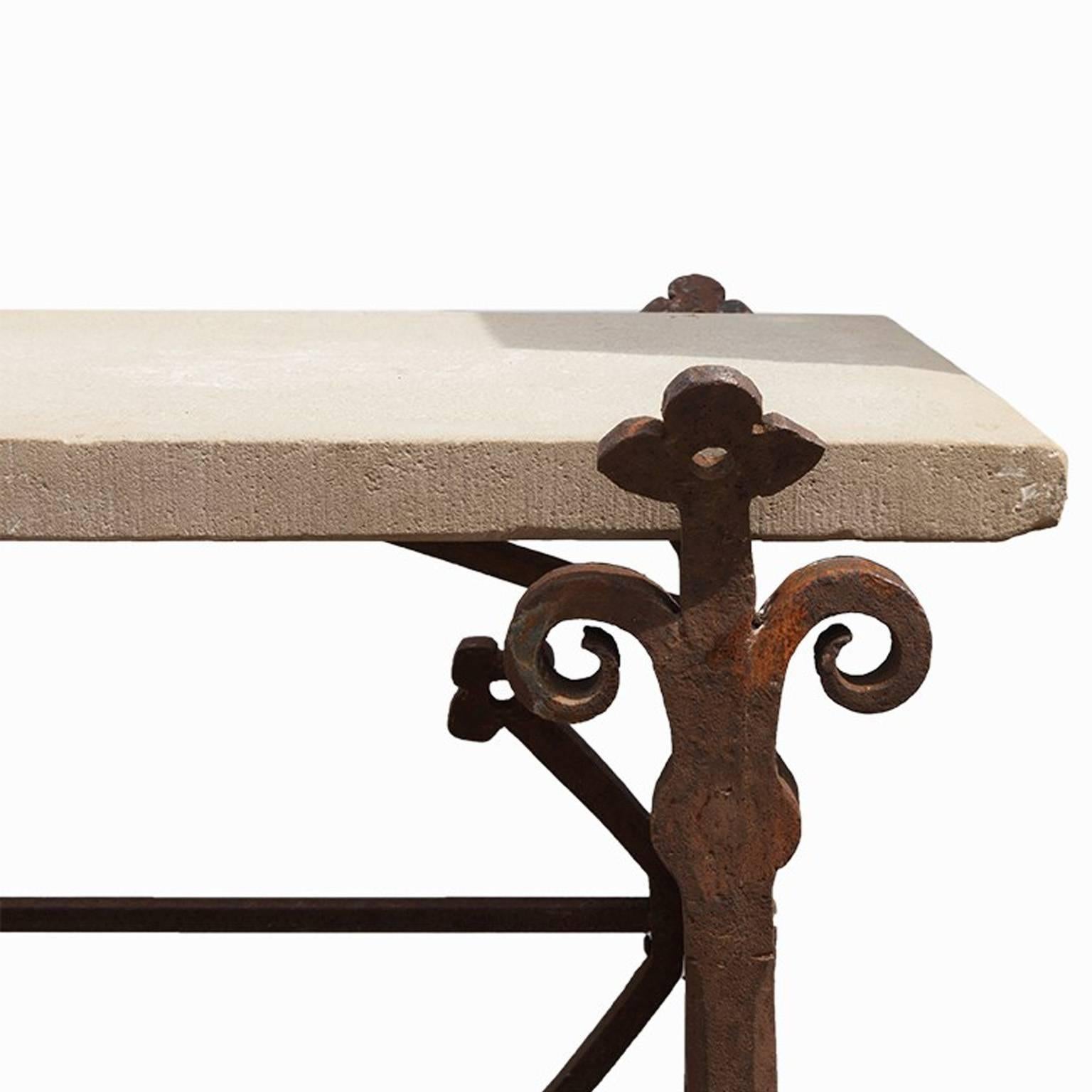 Iron frame of narrow iron struts, with stylized bourbon lilies. Includes a
rectangular stone top limestone with a
hammered finish and straight edges,
circa 1860.