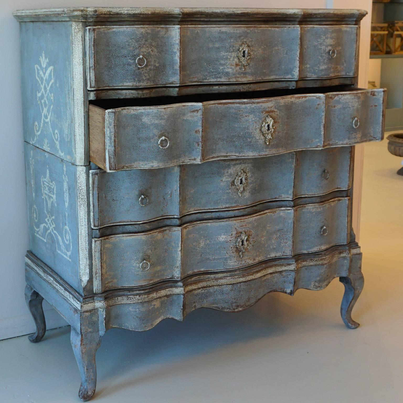 Chest of drawers with wavy front and four drawers. The side panels 
are cut at the bottom the blue painting is completed.
With floral elements on the side panels.