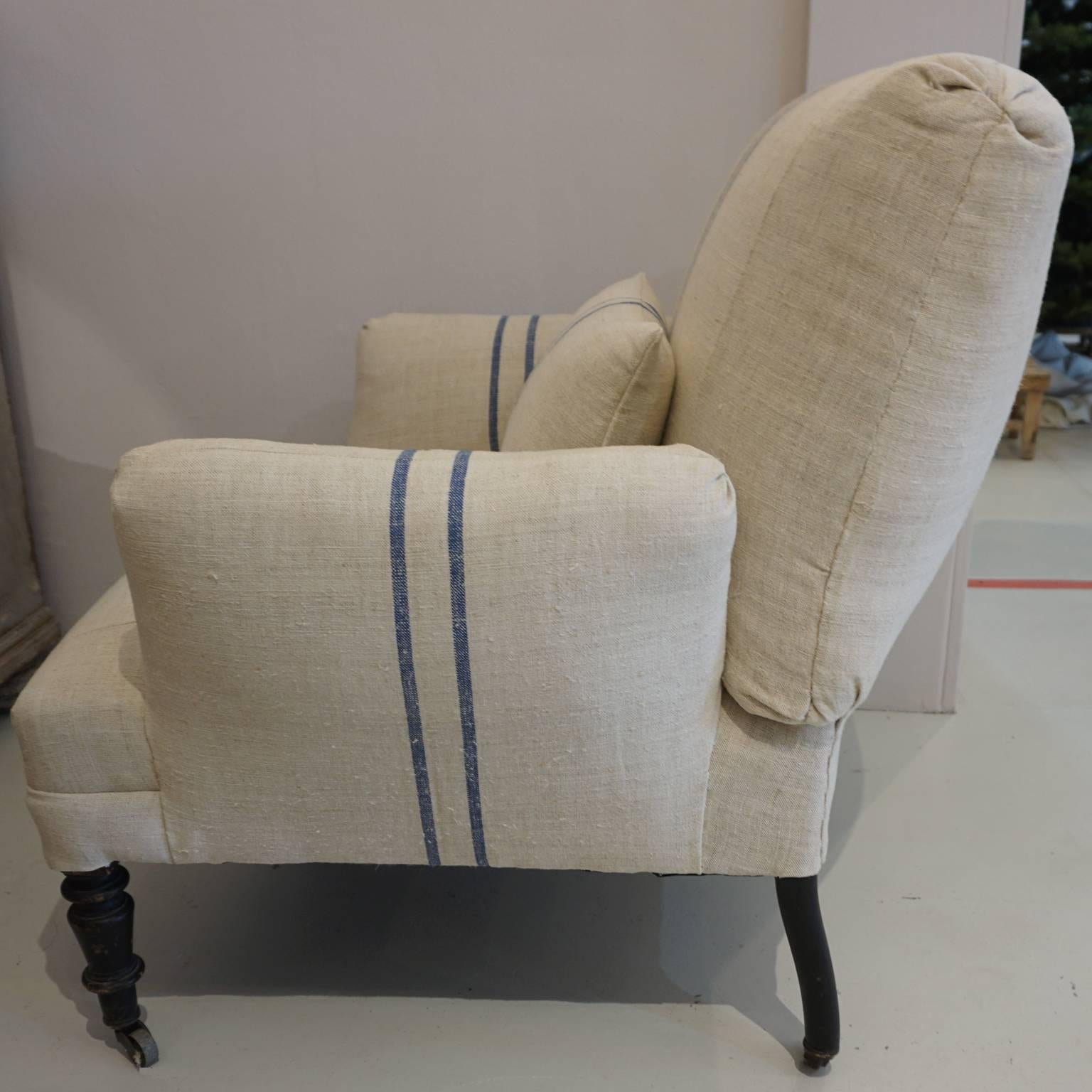 Napoleon III Fauteuil on rollers. Newly re upholstered in antique neutral French burlap back linen with dark blue centered double stripes, thick upholstered armrests. Includes small backrest pillow for additional support, circa 1860, France. The