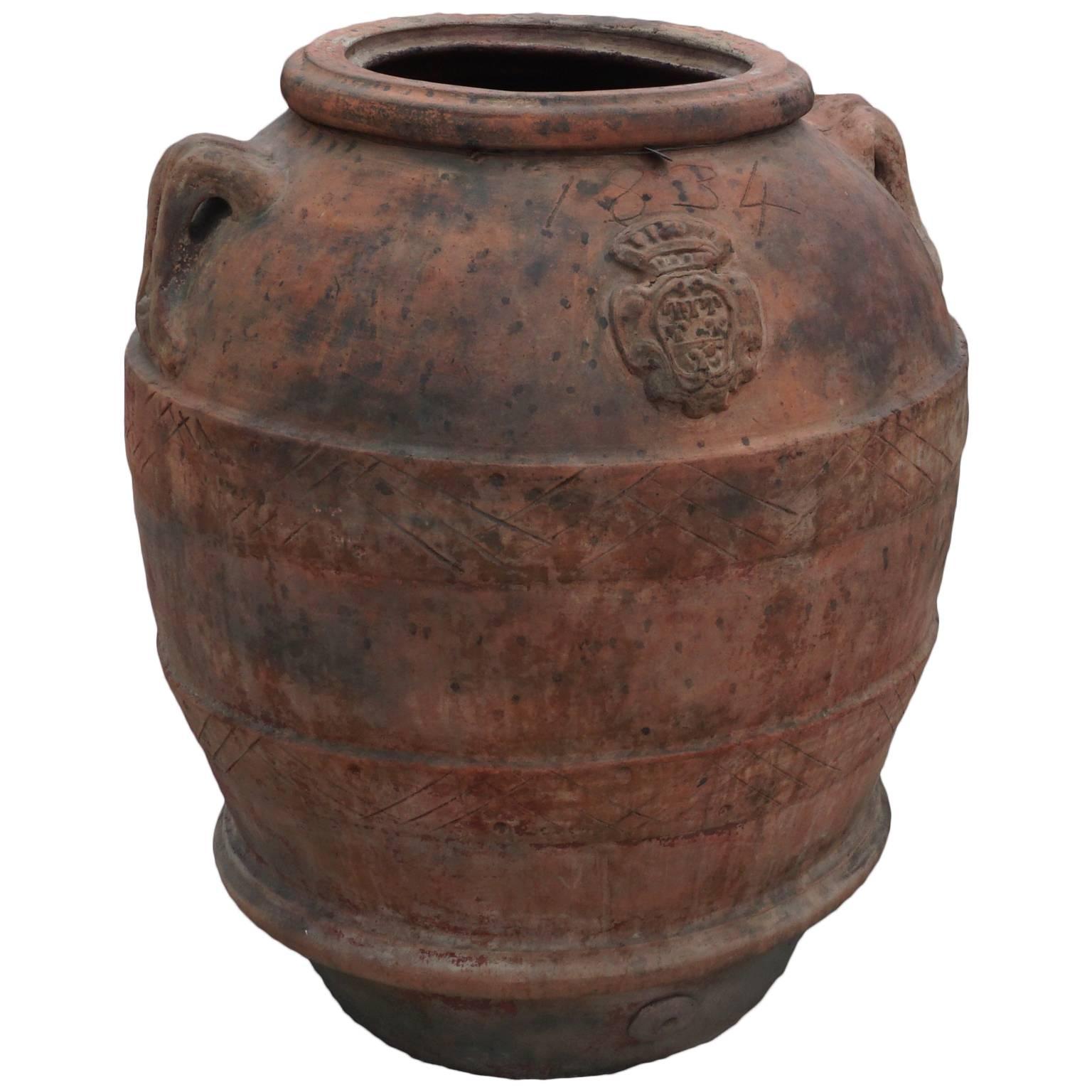 Very large antique Tuscan terra cotta planters which were used for storage of olives and grapes. Lateral handles and shields adorn these massive garden urns. Decorative bands and rolled rim decoration, made of Tuscan clay.