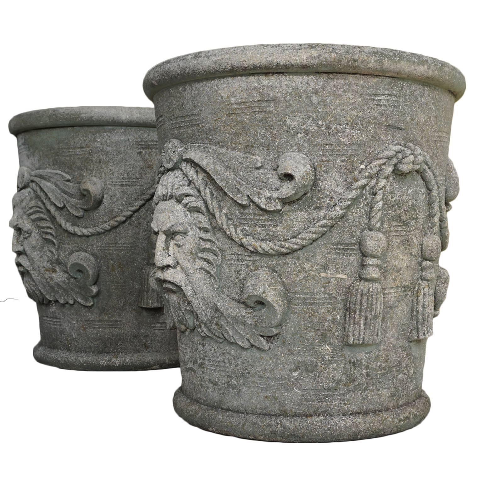 A pair of grand vases with masks from Northern Italy, circa 1930. round garden planters richly decorated with masks and ropes in the Renaissance style, hand-carved in limestone.