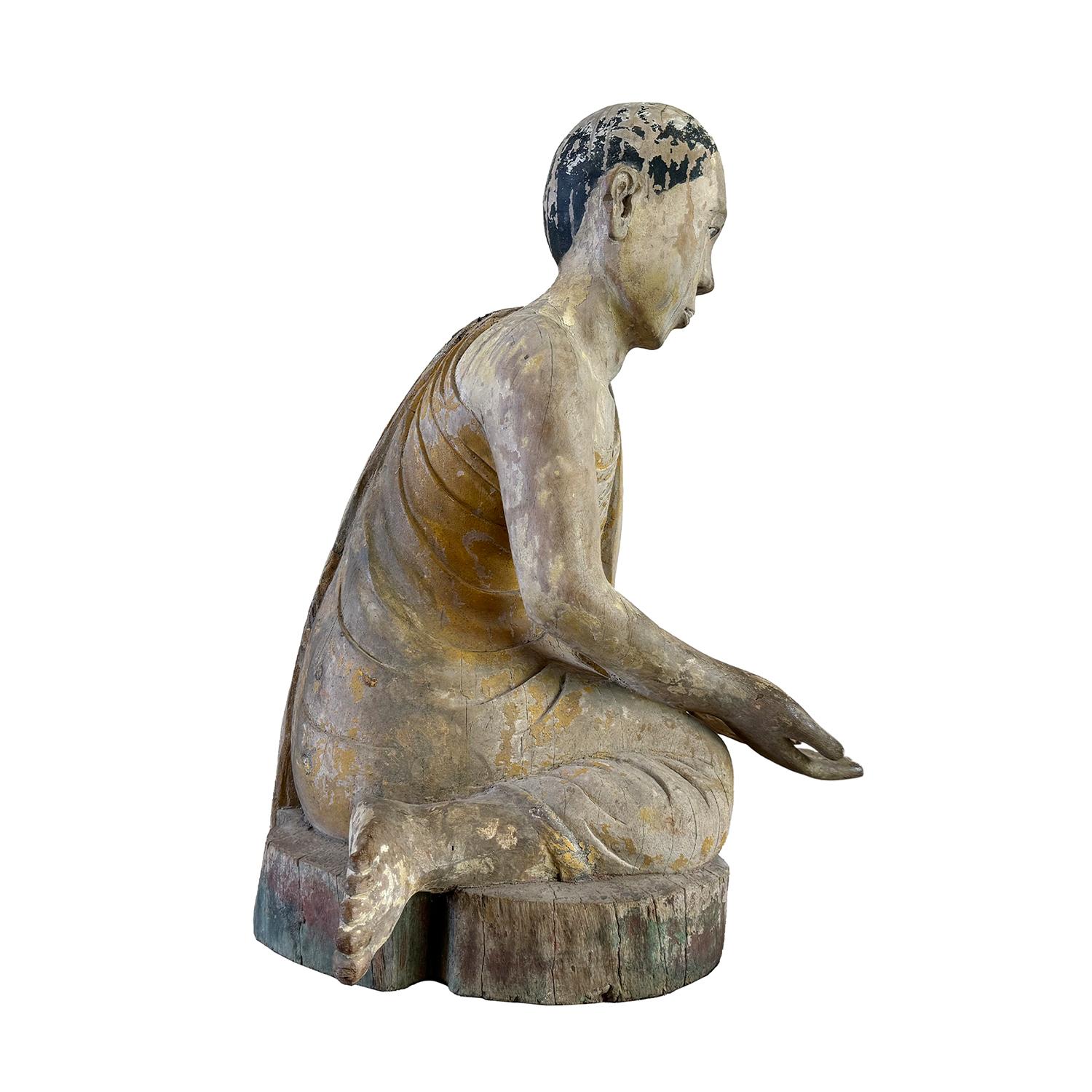 Ancienne sculpture asiatique sereine en bois de teck représentant un moine agenouillé en Anjali Mudra, le geste traditionnel de Revere et de salutation, en bon état. Sculptée à la main avec des détails délicats et des traces de pigments originaux,