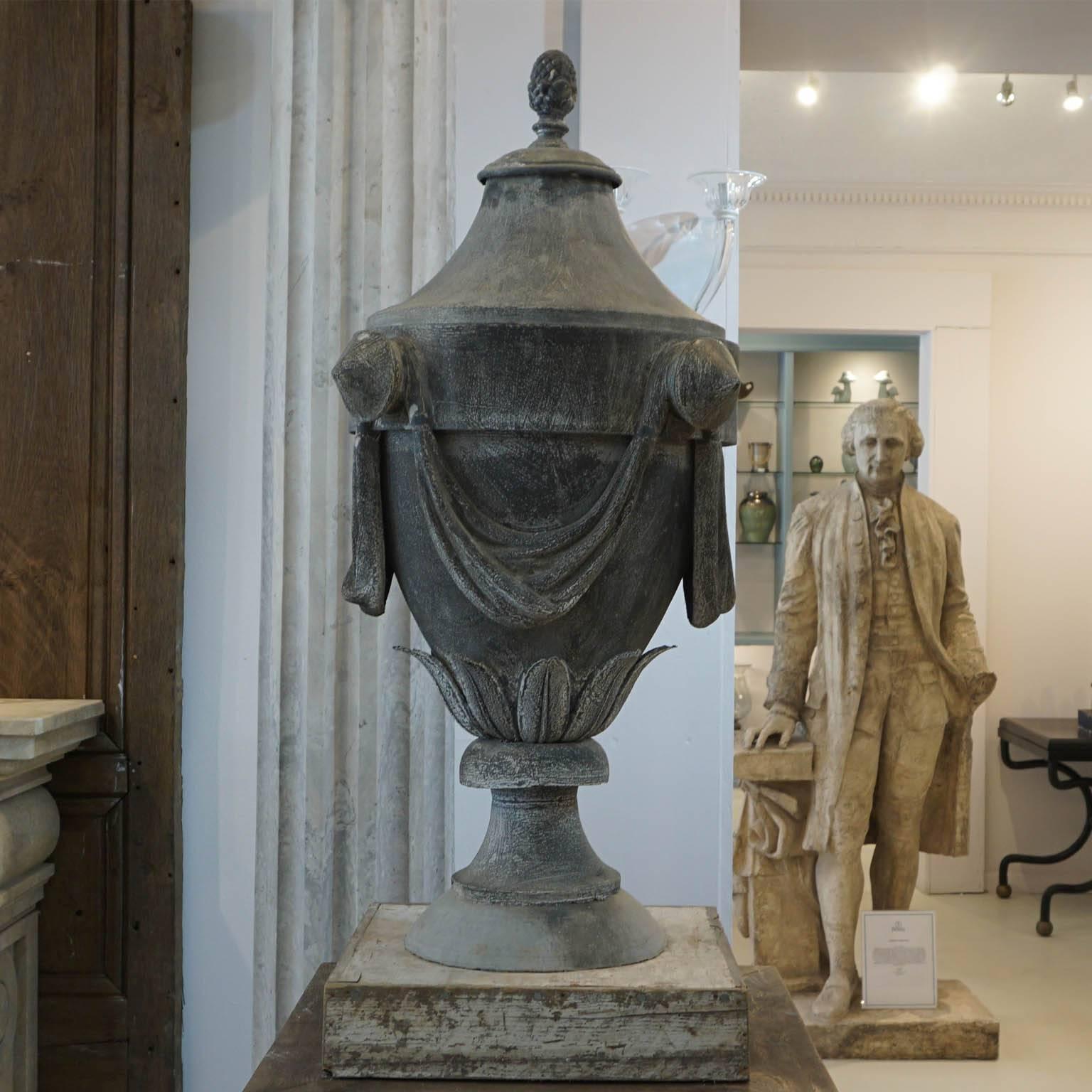 Mid 19th Century, Impressive pair of zinc finials decorated with swags, leaves and topped with a pomme de pin. The draped urn finials originate from a chateau located in the Loire region in France. Installed on antique oak wood plinths. 
Urn