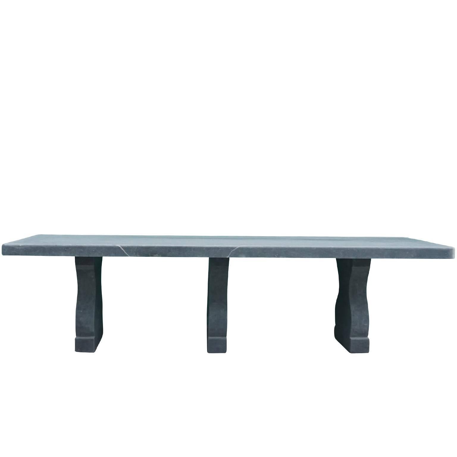 Massive and of maximum length this Belgian blue stone dining table is truly stunning. It is of simple elegant lines, rounded corners and three table bases. Honed surface and without decor. Exterior / interior. The tabletop is showing a shadow of a