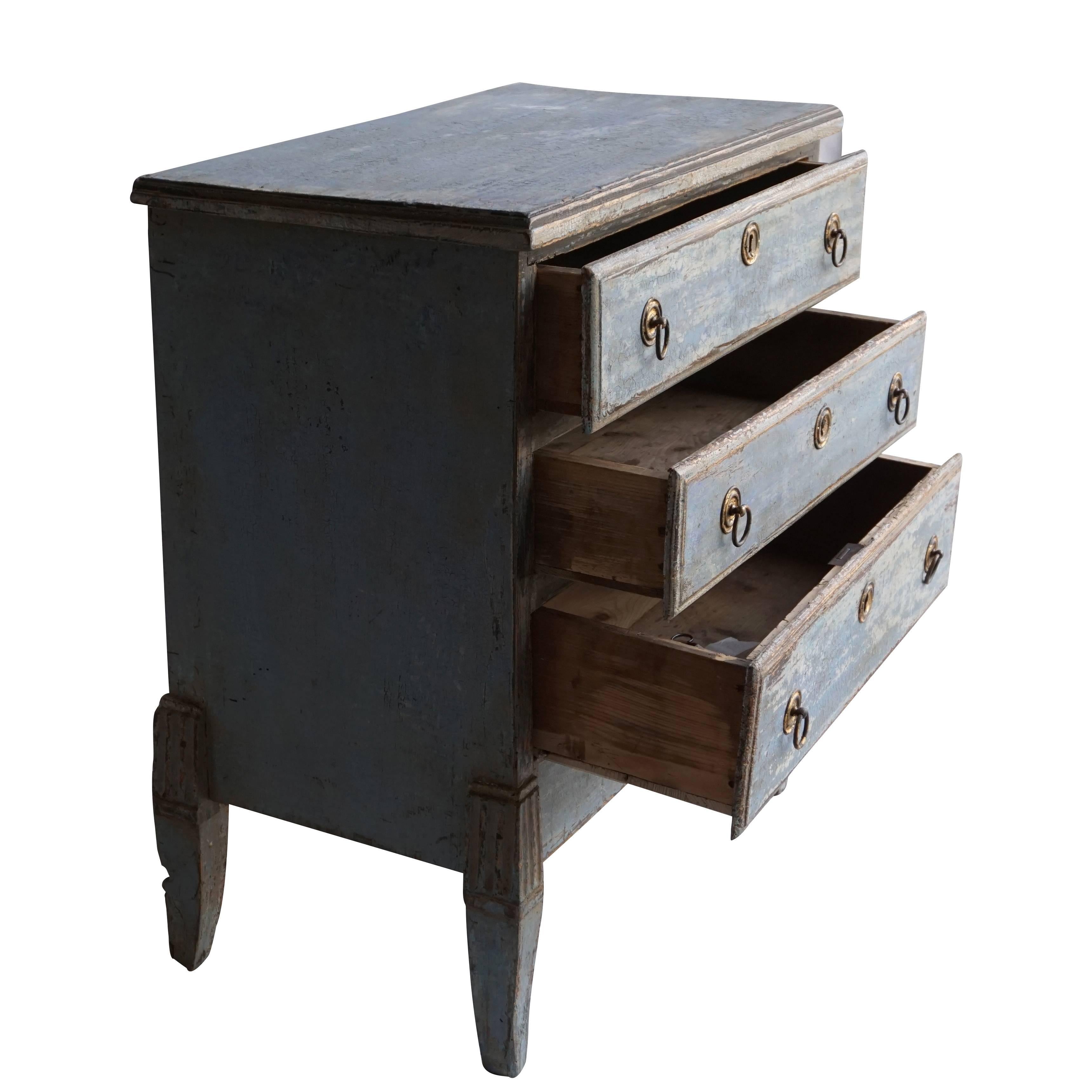 Swedish three-drawer dresser with original hardware and lion brass hardware on the centre of the bottom, circa 1780. The legs are tapered and the drawer dresser has the original blue grey finish. Pinewood, antique patina. Prov. Sweden, Scandinavia